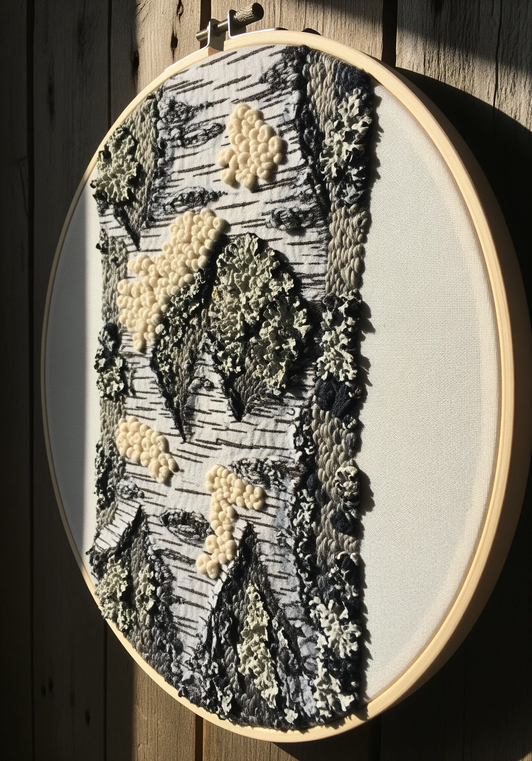 Embroidery hoop art showing birch bark texture with French knots and straight stitches.