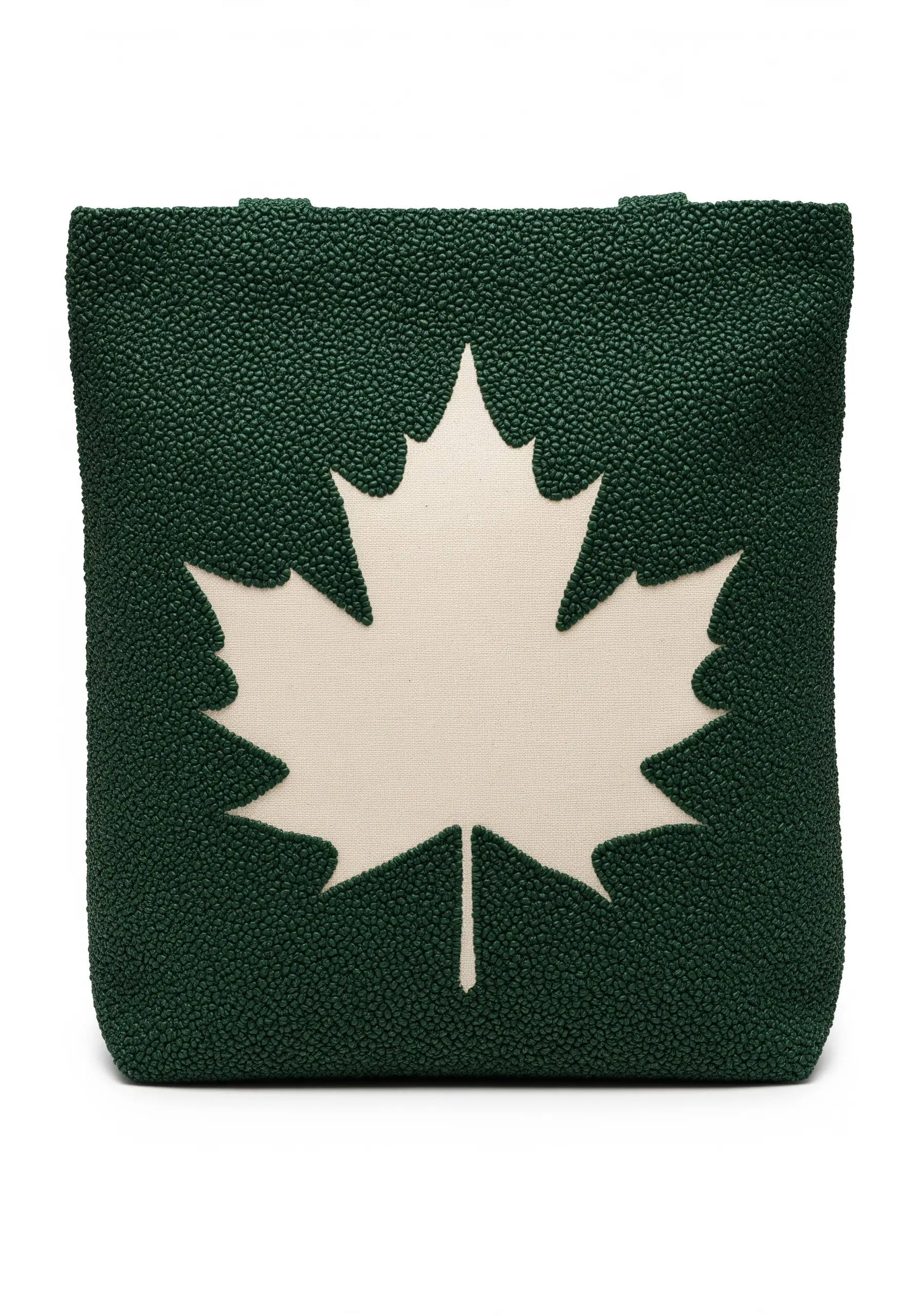 A tote bag with a cream maple leaf created through reverse appliqué on textured green fabric.