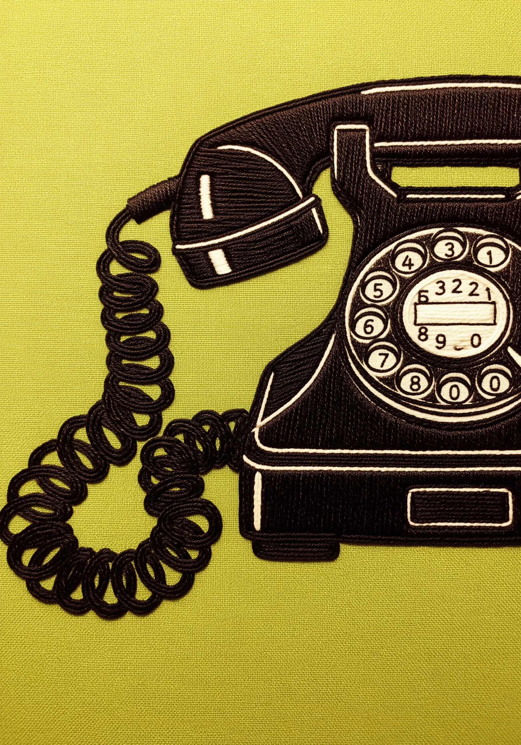 A vintage rotary phone with a textured, 3D coiled cord made from bullion knots.