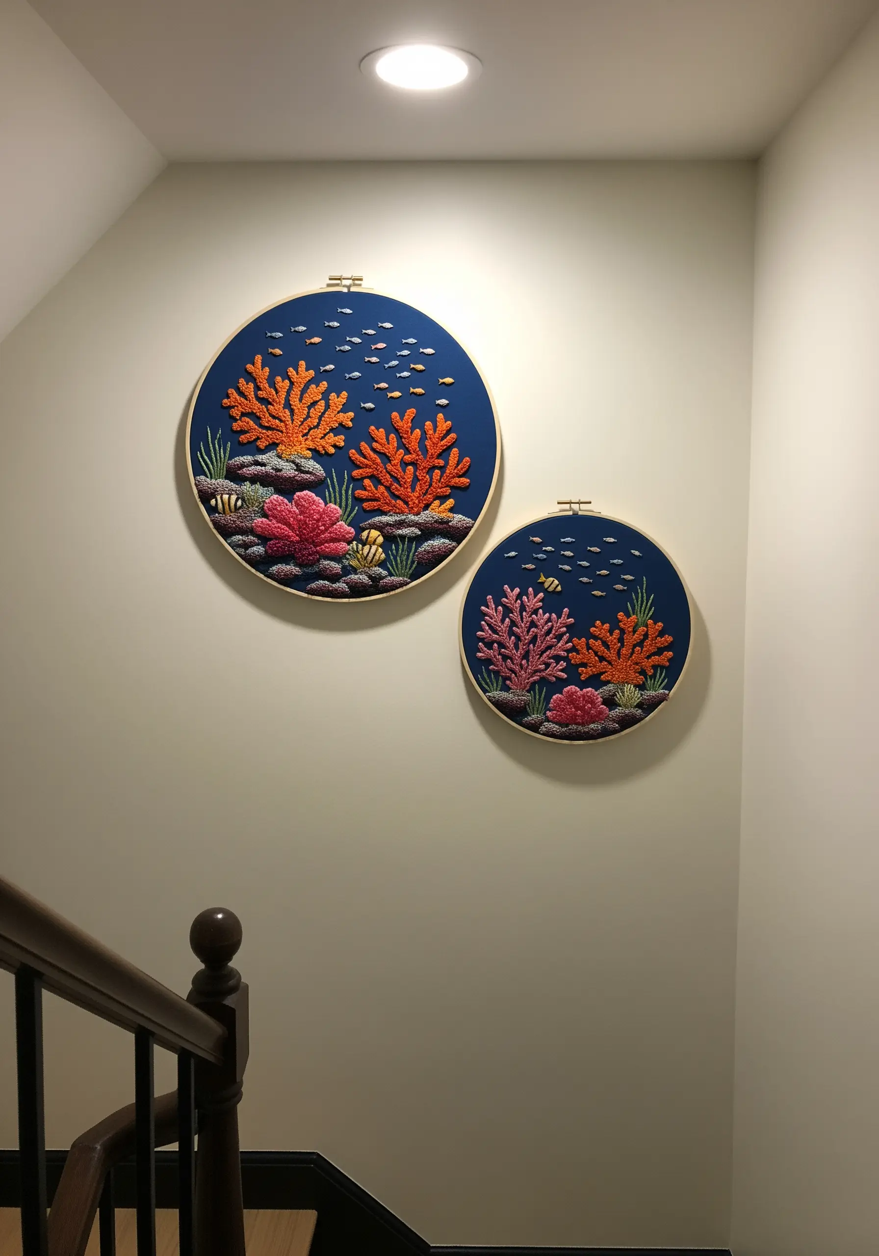 Two embroidery hoops depicting a colorful coral reef scene against a dark blue background.