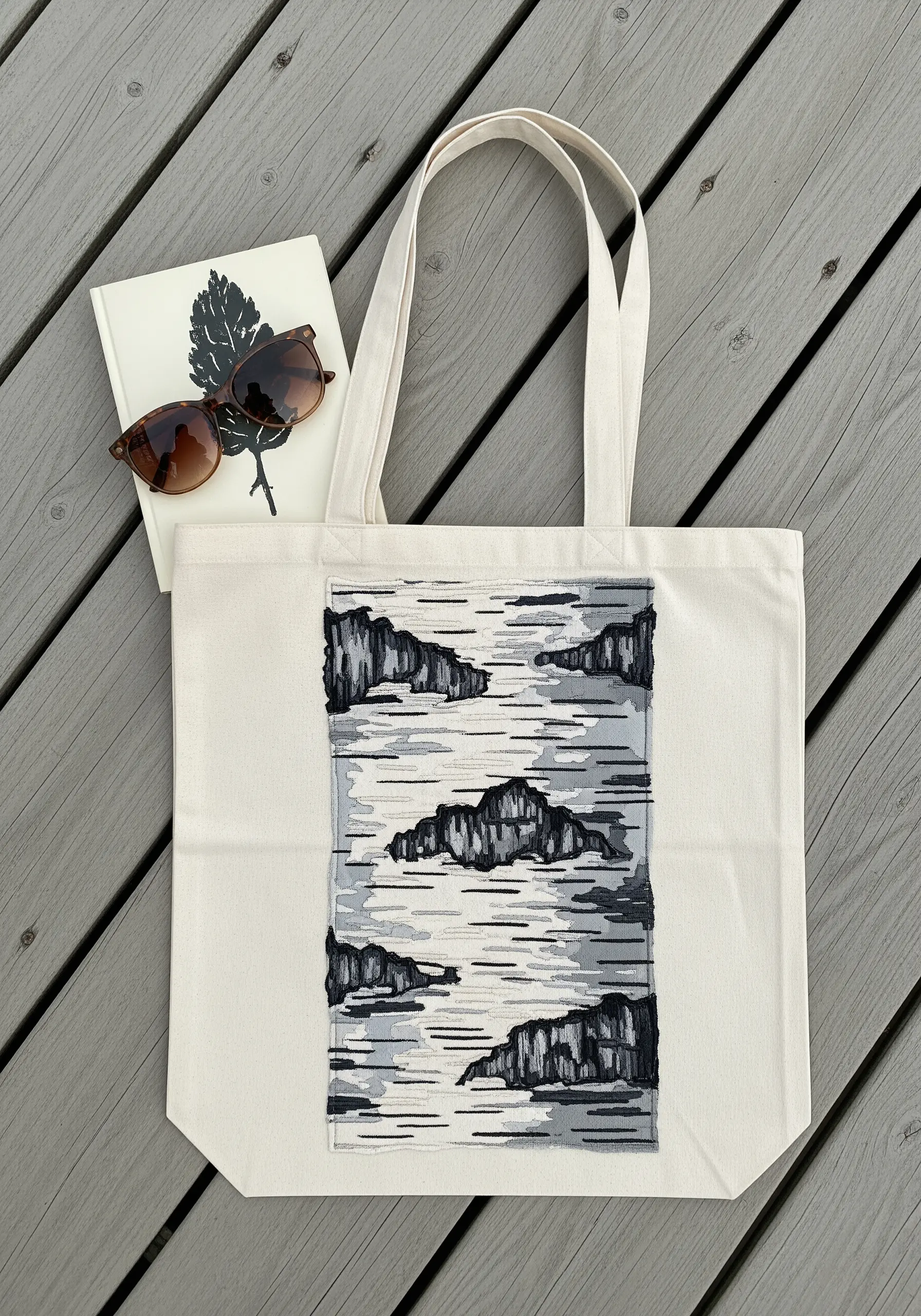 An embroidered patch on a tote bag showing a birch bark texture with satin stitch.