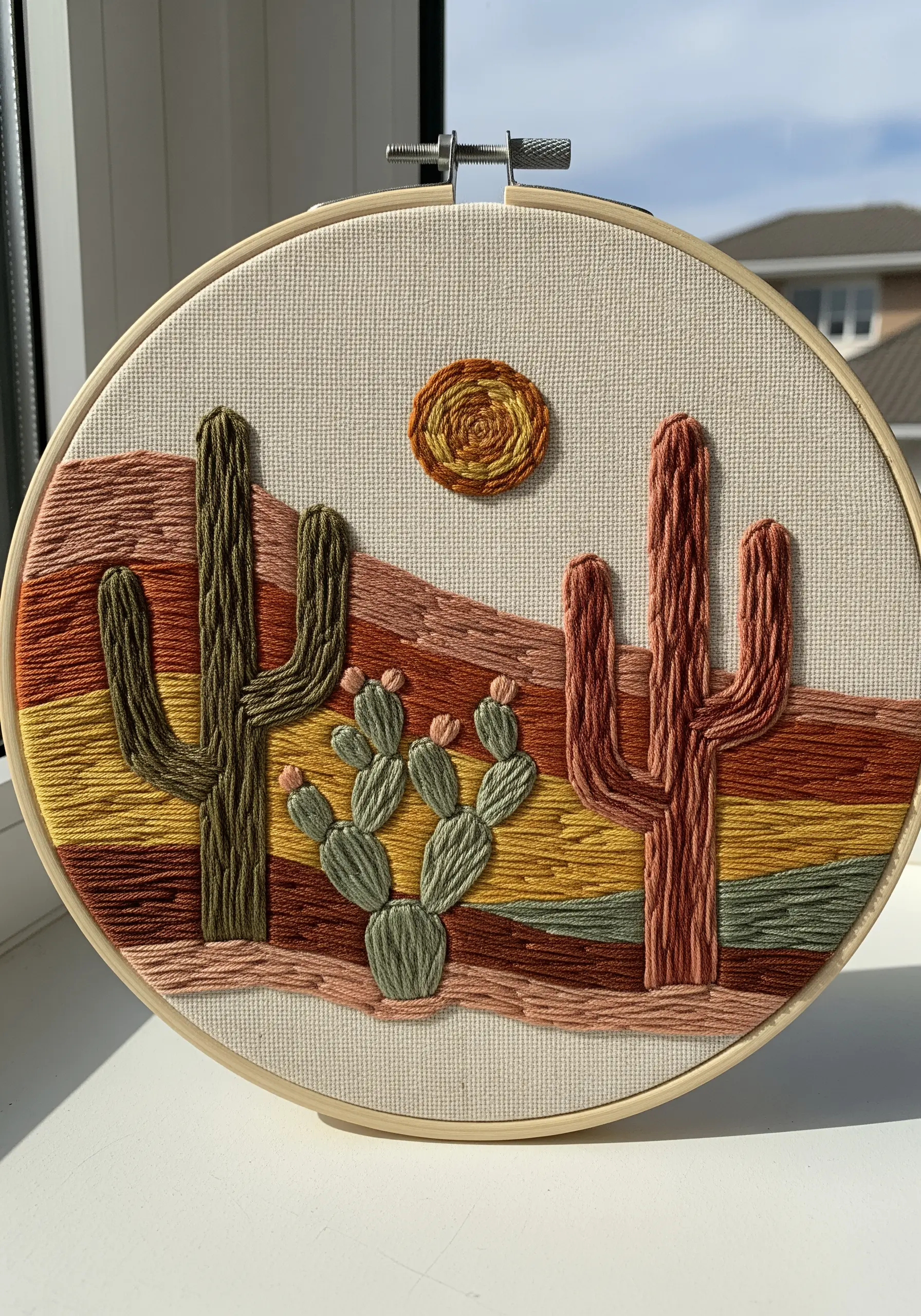 A desert landscape with cacti, using horizontal satin stitch blocks for the background.