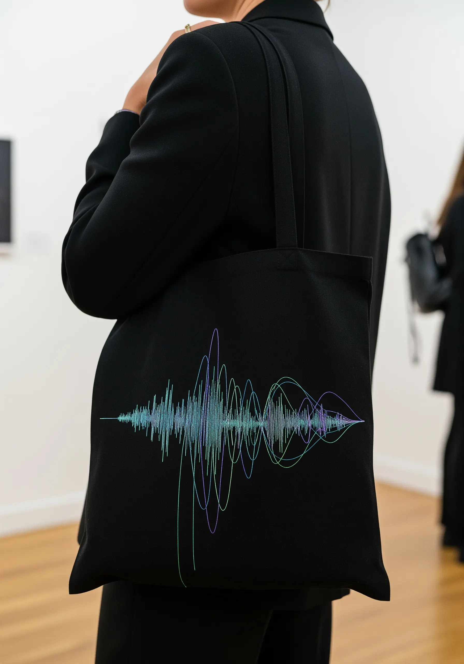 A delicate, multi-colored soundwave embroidered on a black tote bag.