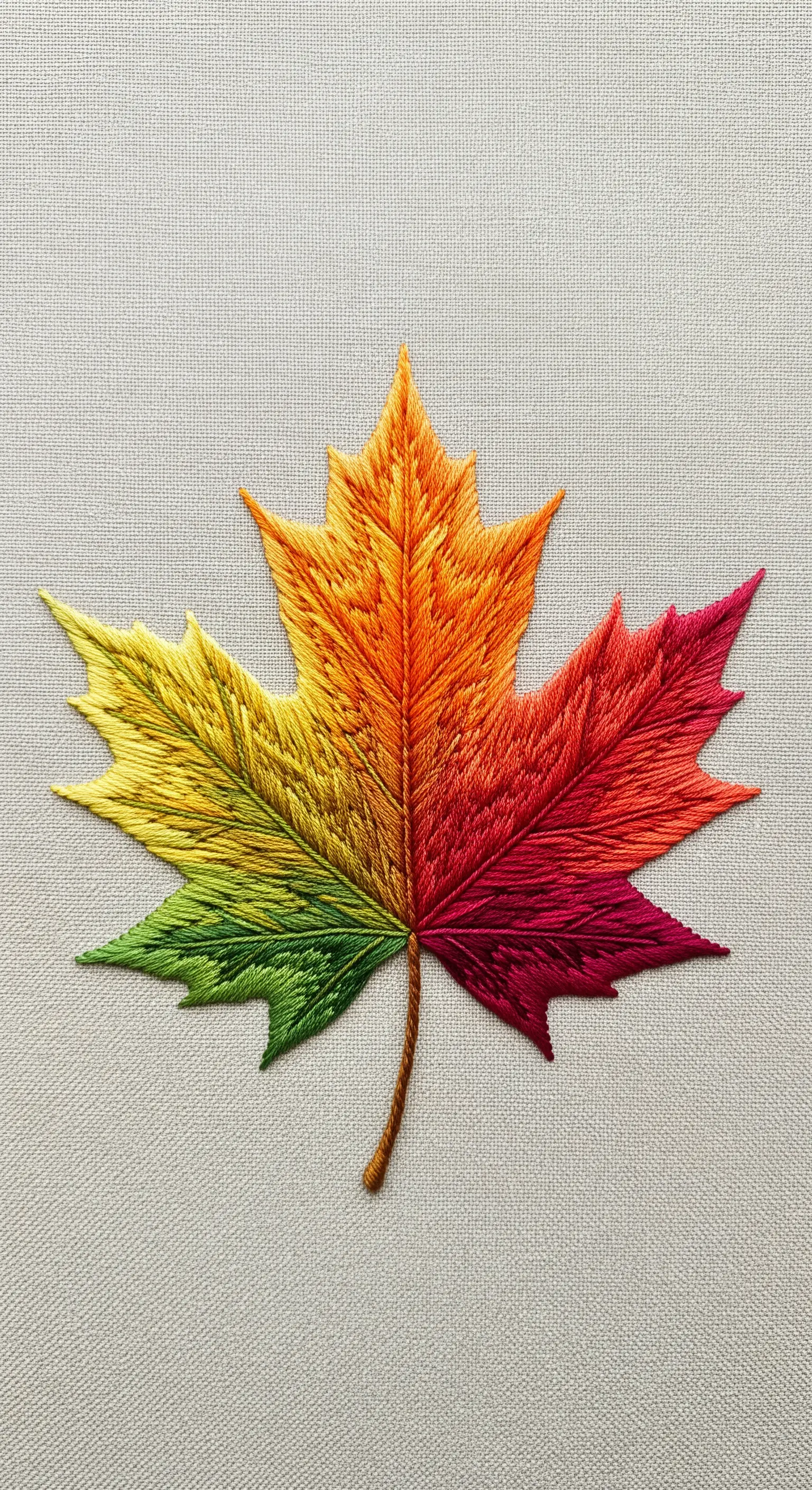 A realistic maple leaf embroidered with a smooth autumn gradient of colors.
