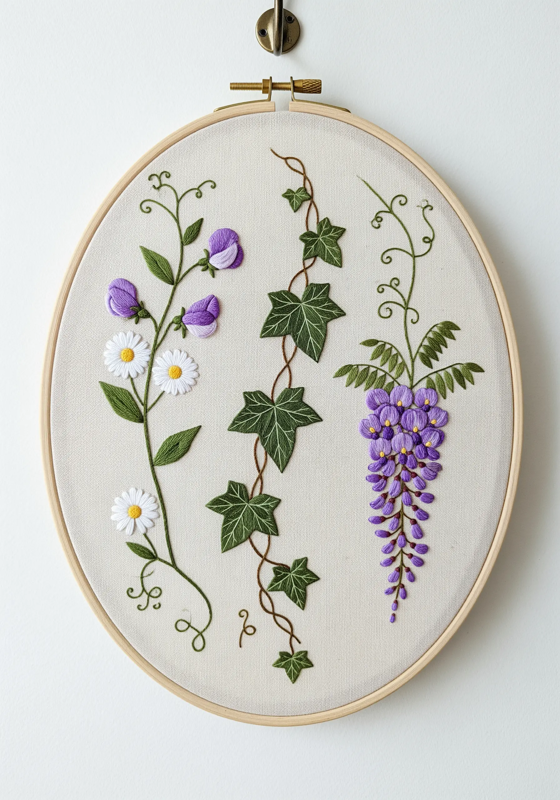 Embroidered climbing plants including sweet pea, ivy, and wisteria in an oval hoop.