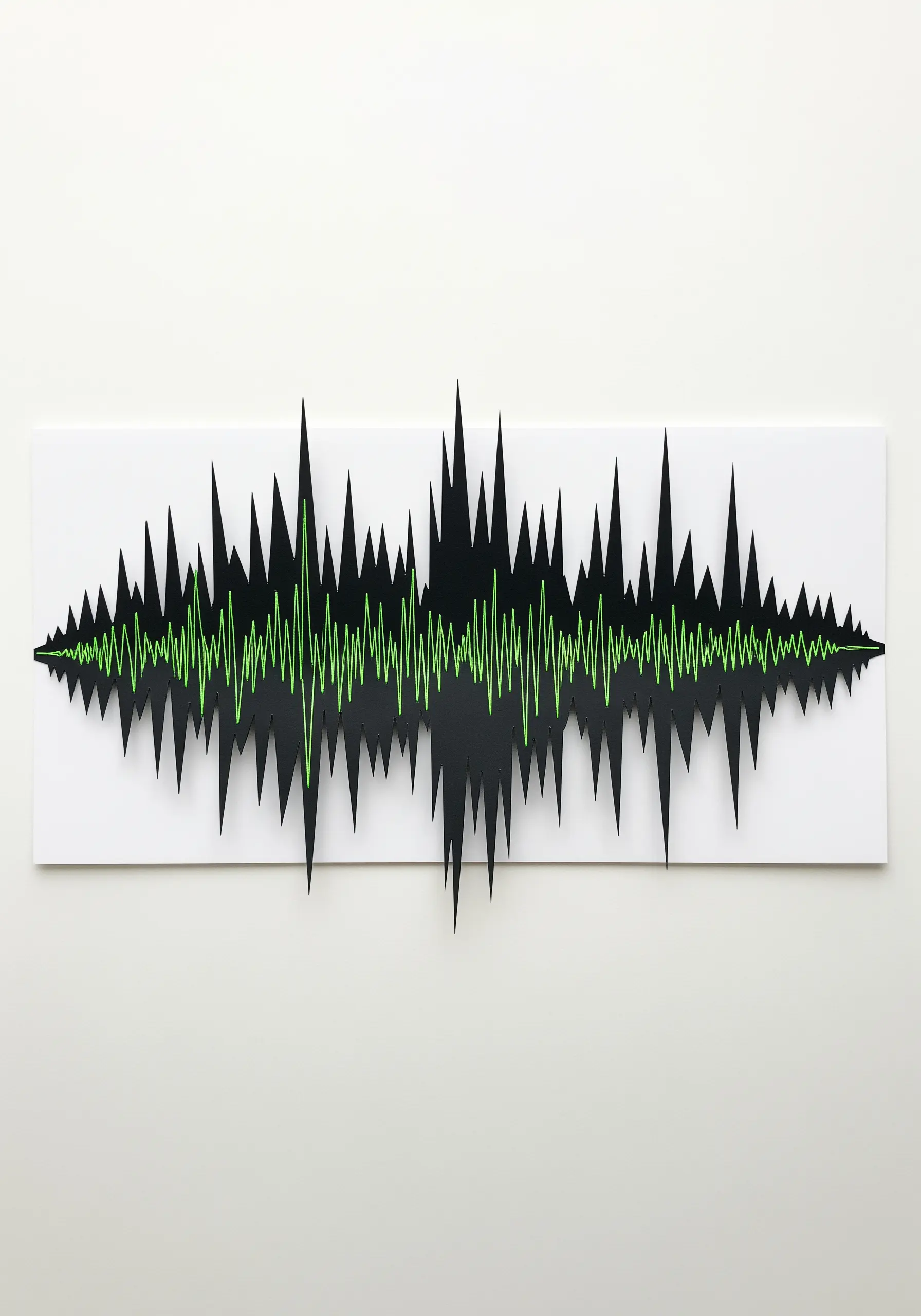 A soundwave made from black cut paper with the central wave stitched in bright green thread.