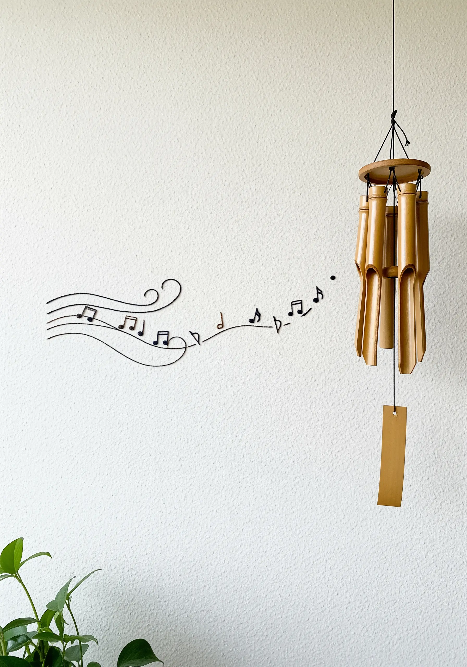 Abstract embroidery of musical notes flowing from a wind chime.