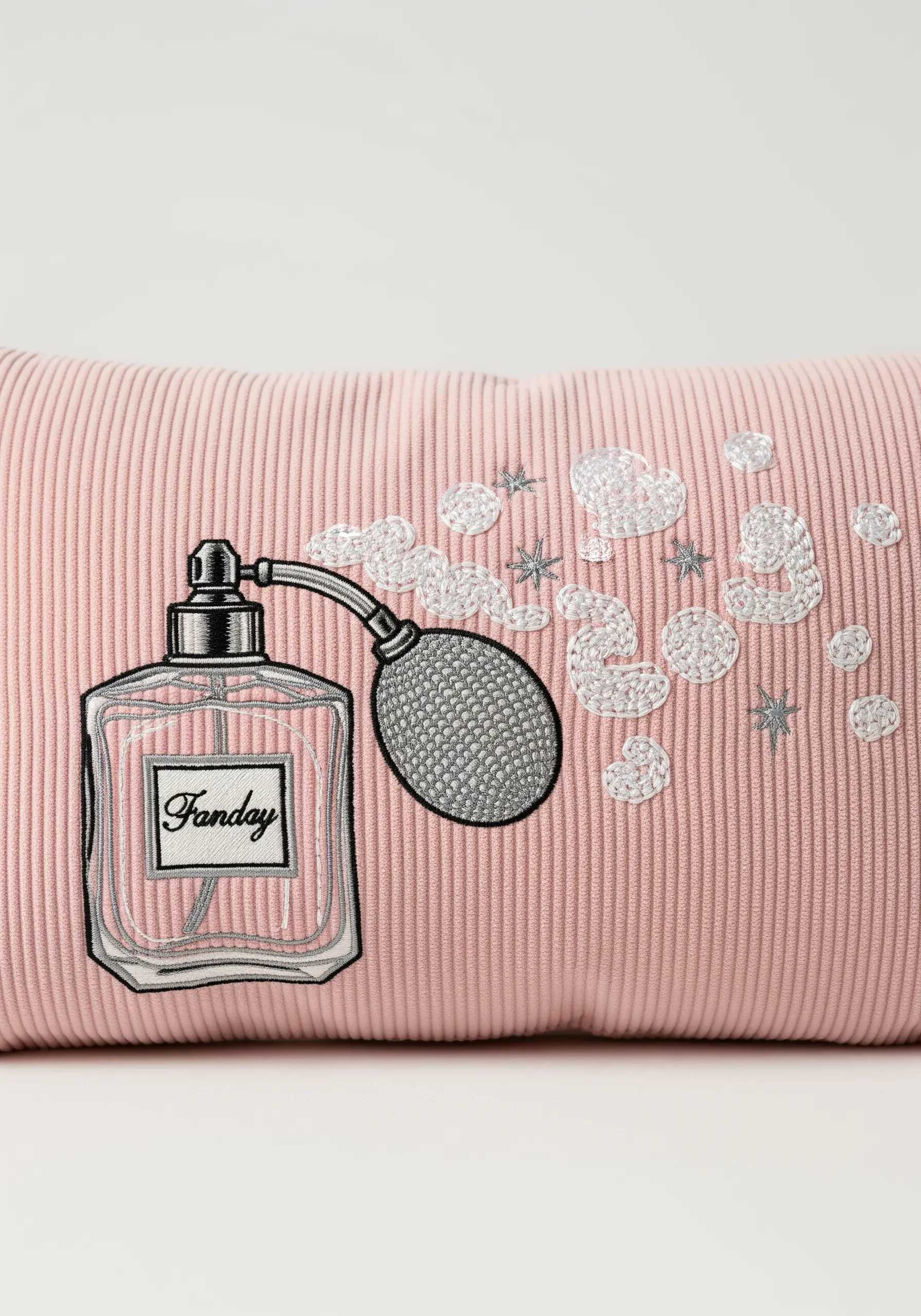 Vintage perfume bottle embroidered on a pink corduroy pillow.