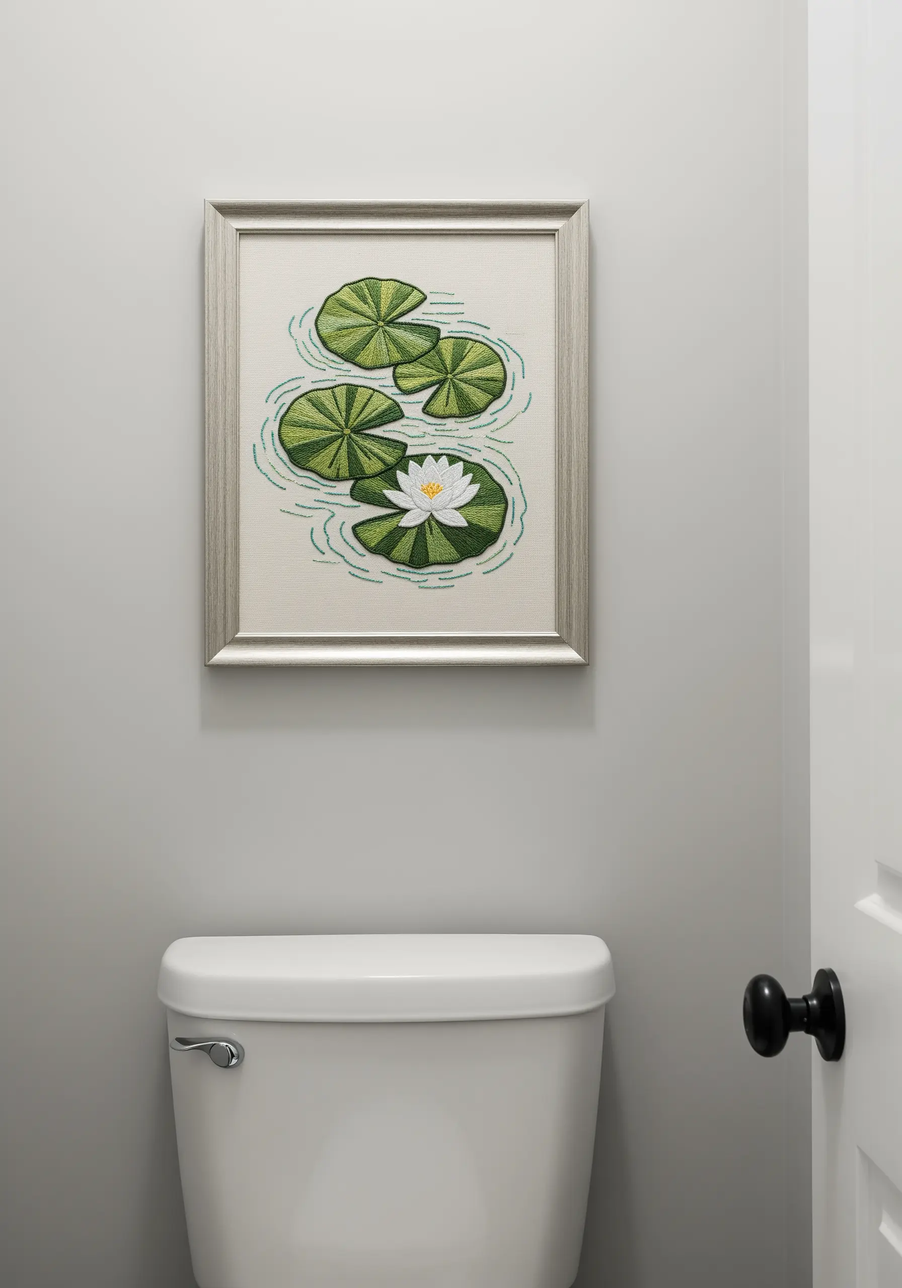 An embroidered piece of water lilies and lily pads with simple stitched water ripples.