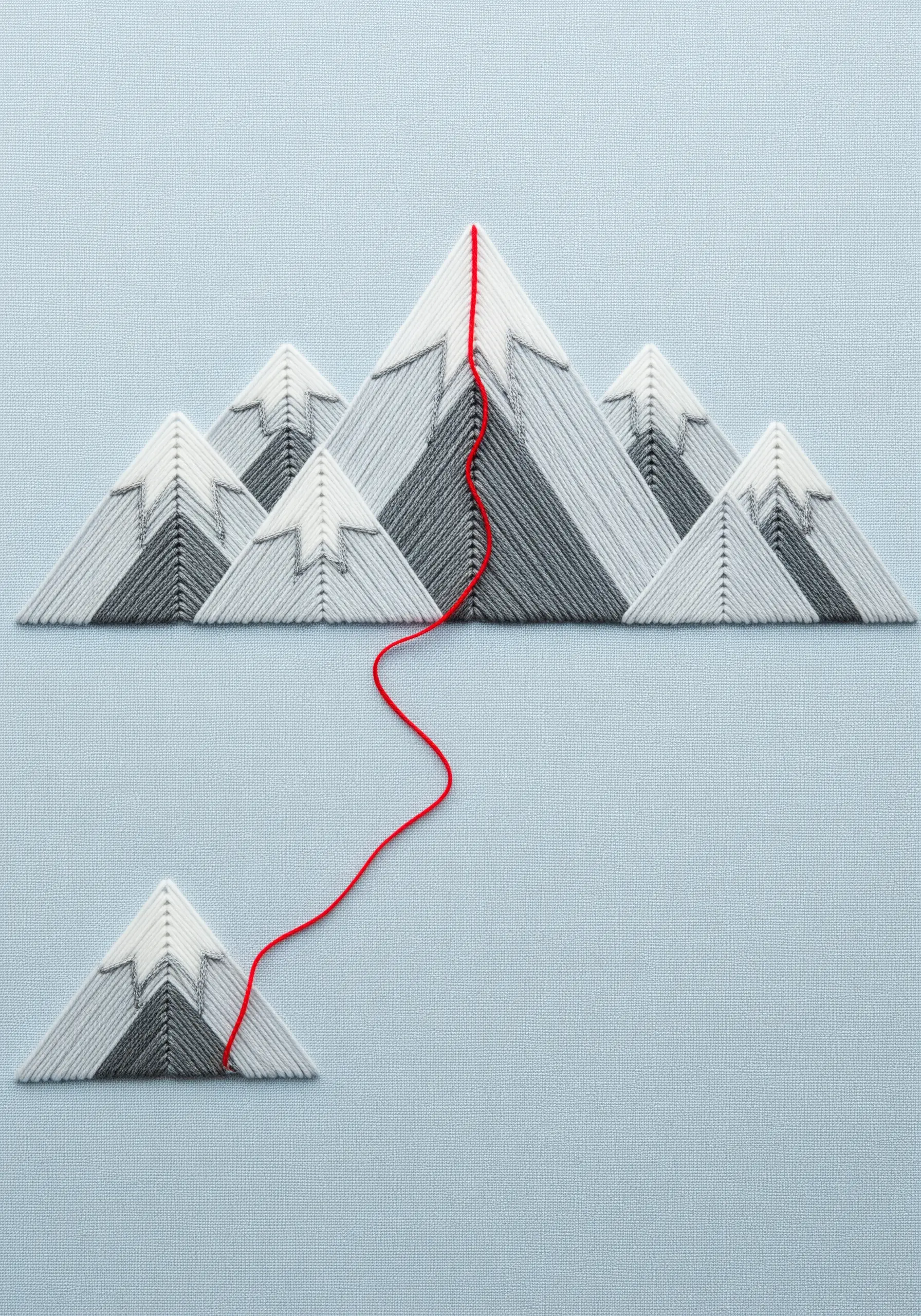 Satin-stitched mountain range in grayscale, with a bright red thread showing a path to the summit.