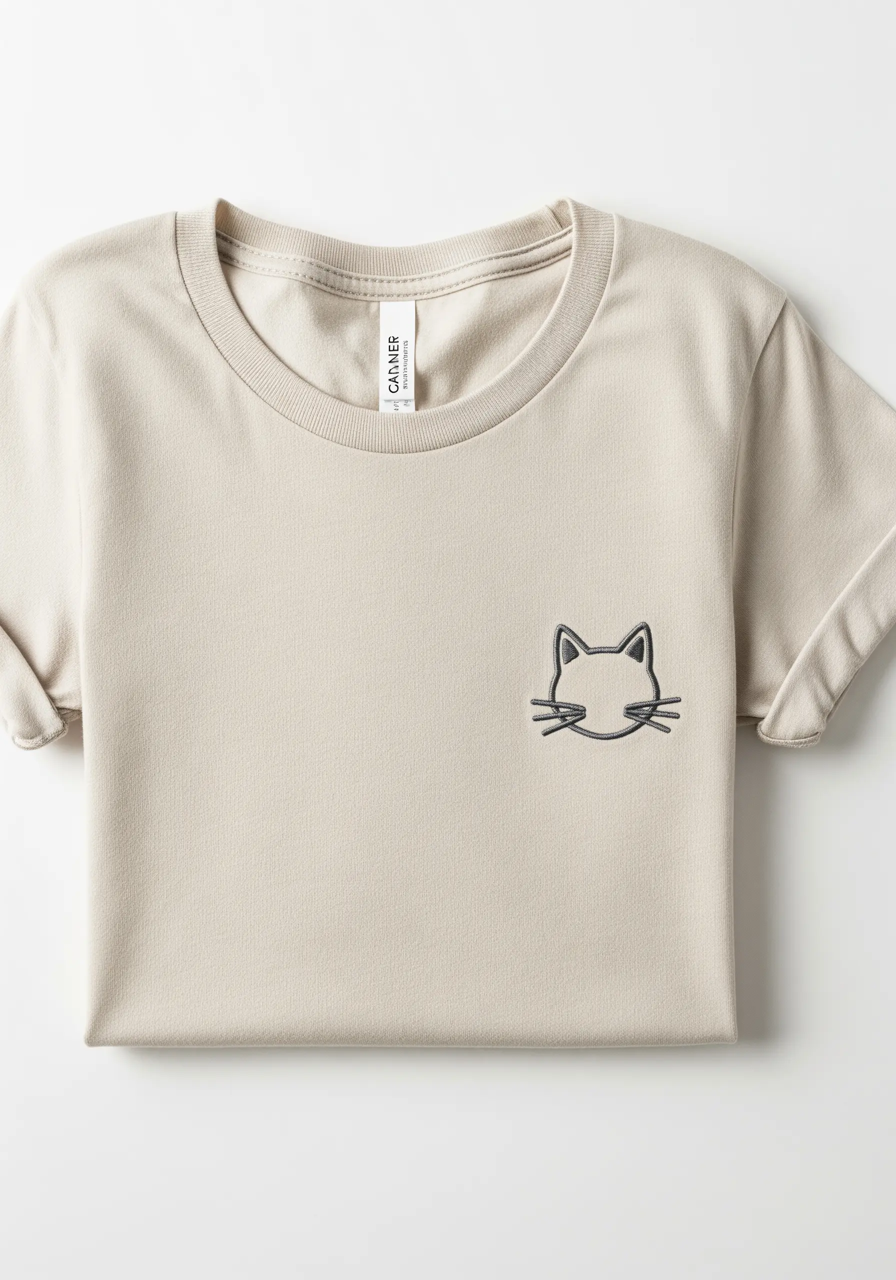 A minimal cat face outline with a thick grey border on the chest of a beige t-shirt.