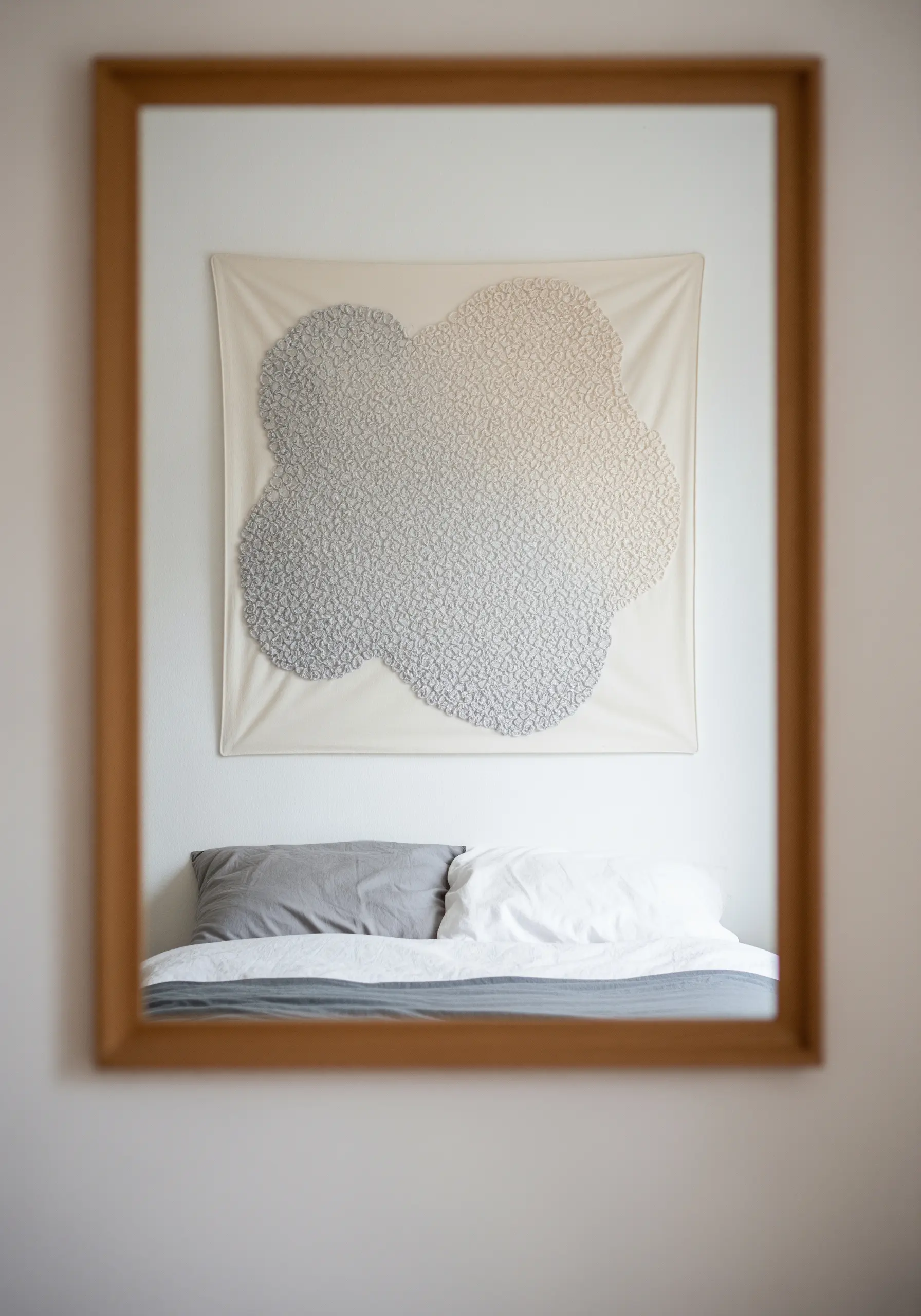 A cloud-shaped embroidery filled with French knots in a grayscale gradient.