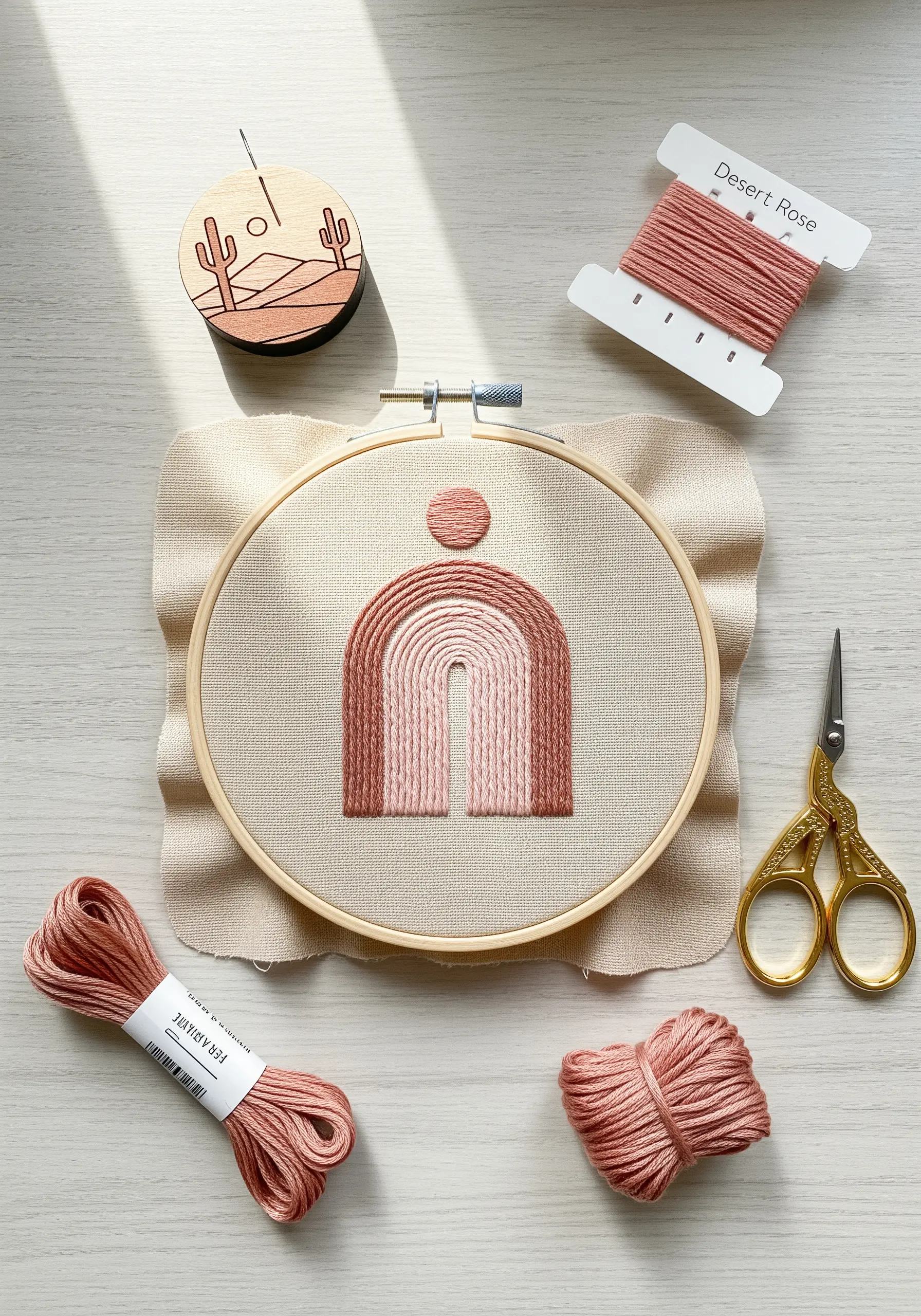 A modern abstract arch embroidered with a gradient of pink and rose threads.