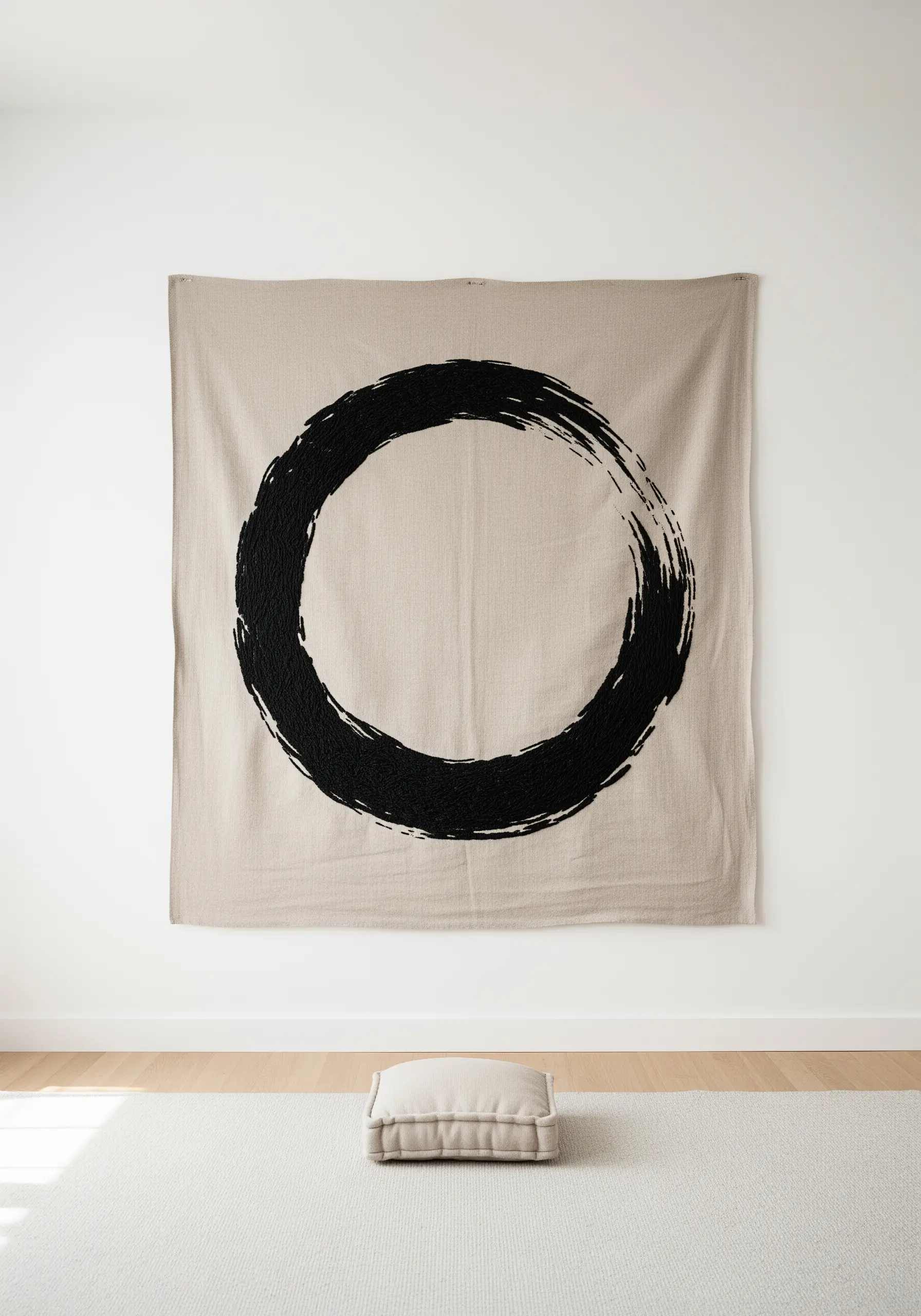 A large black embroidered Enso (Zen circle) on a neutral linen wall hanging.
