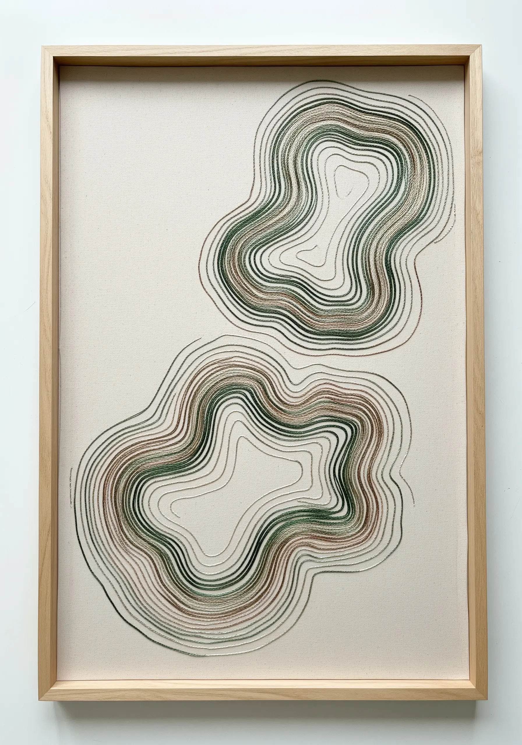 Abstract topographic line art embroidered with green, brown, and grey thread.