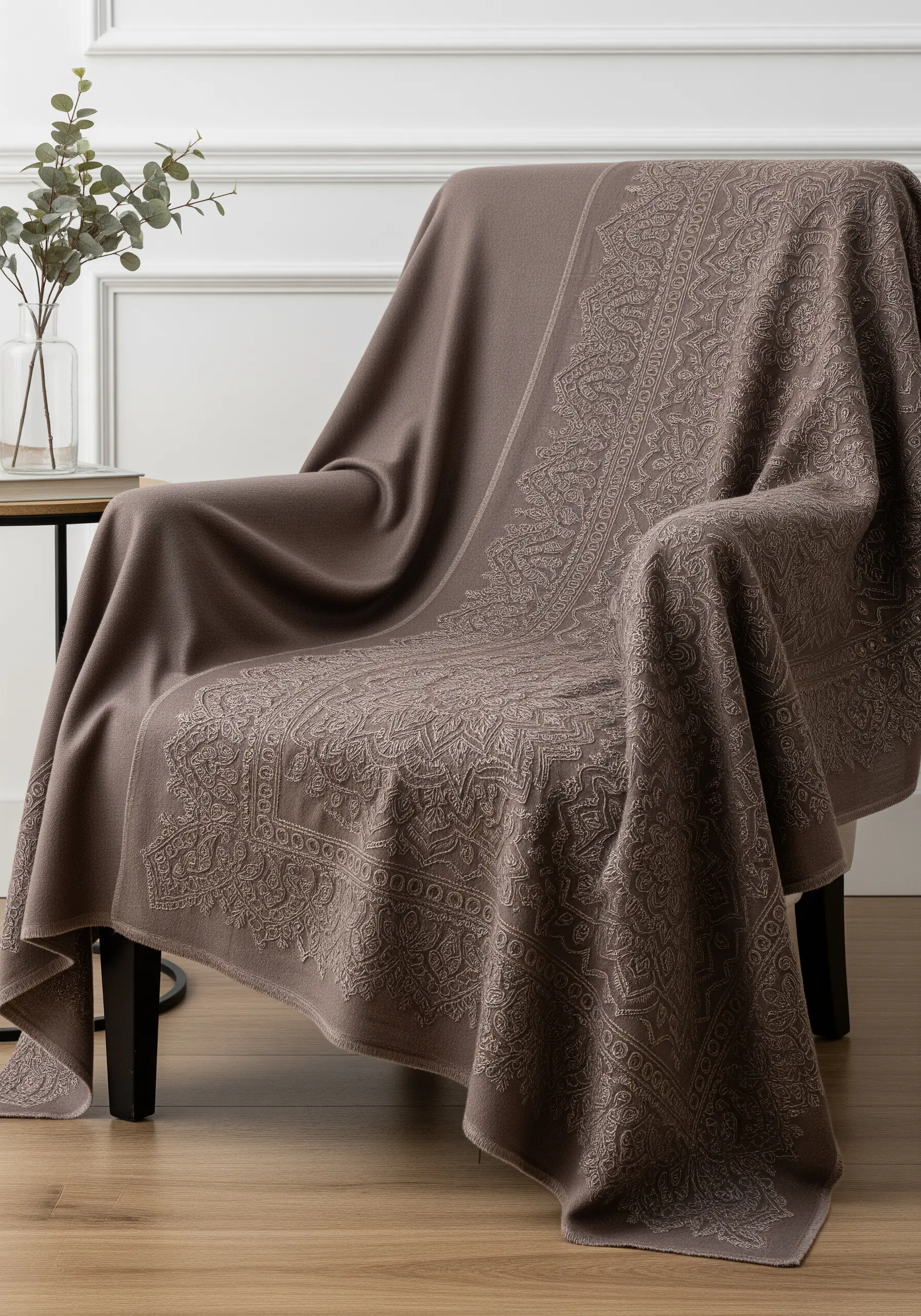 An intricate, tone-on-tone mandala embroidered onto a luxurious, soft brown cashmere throw.