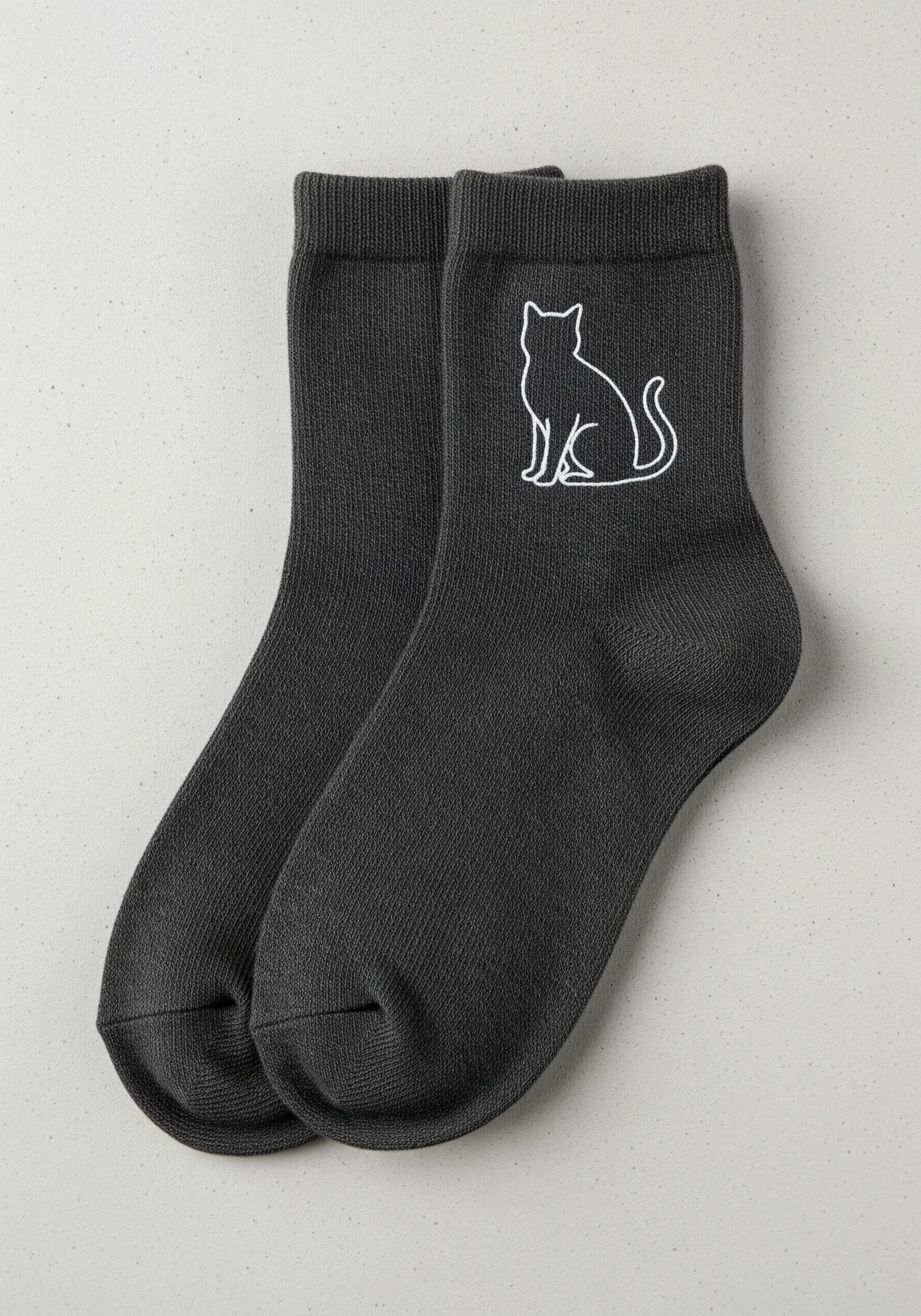 A simple white line-art cat silhouette embroidered on the ankle of a dark gray sock.