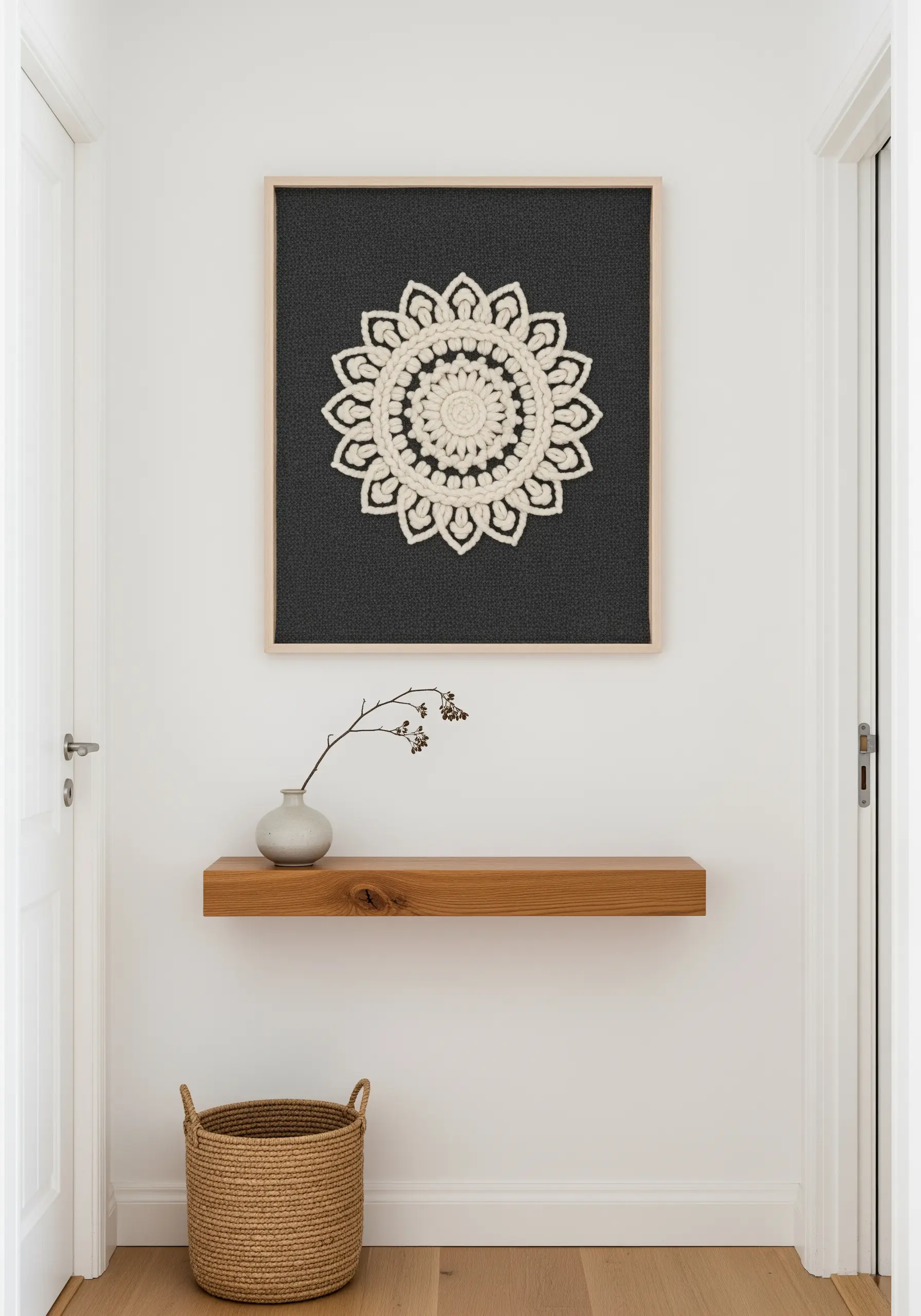 A high-contrast cream mandala with thick stitches, framed and hung on a minimalist white wall.