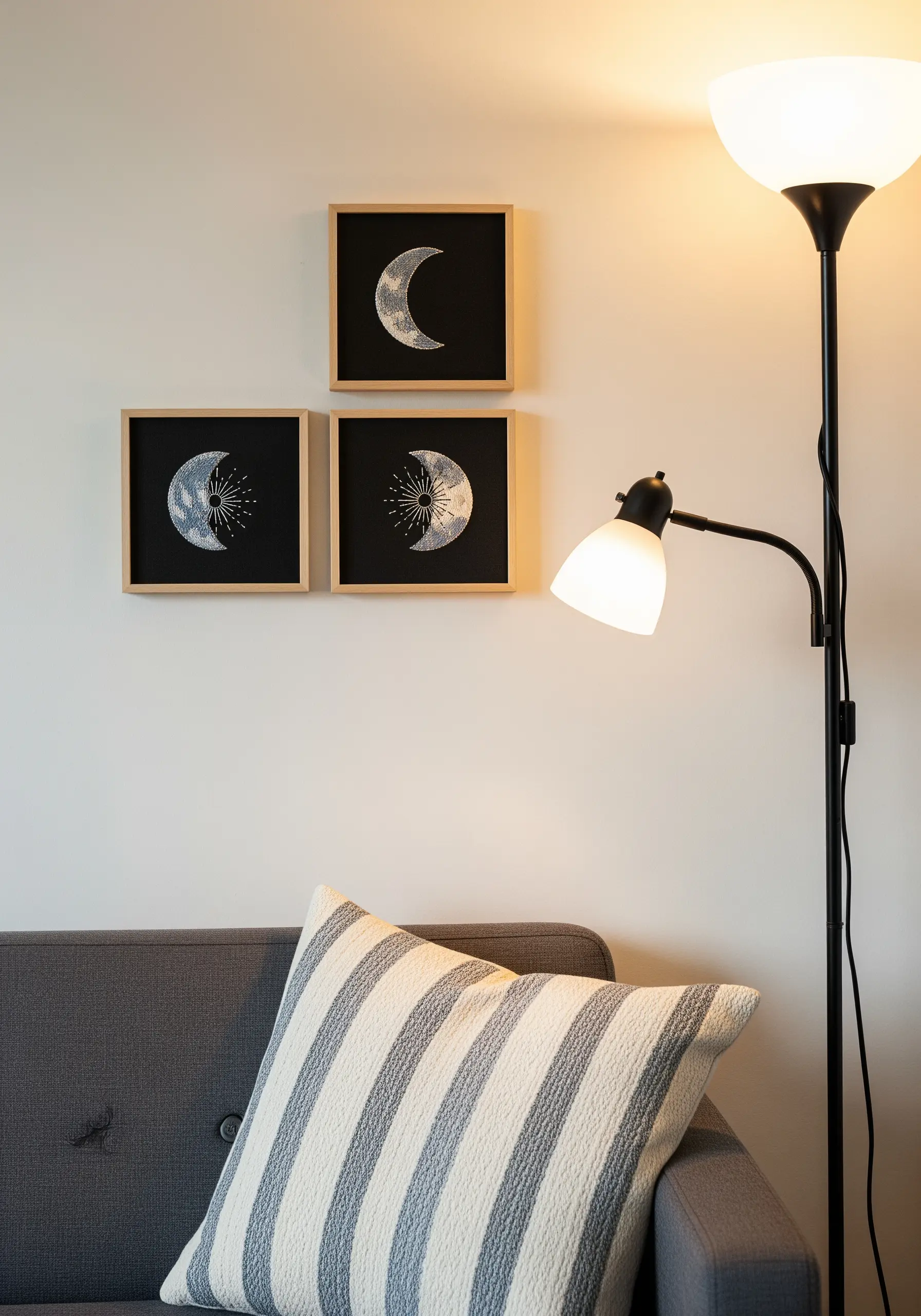 Three framed embroideries of moon phases on black fabric.