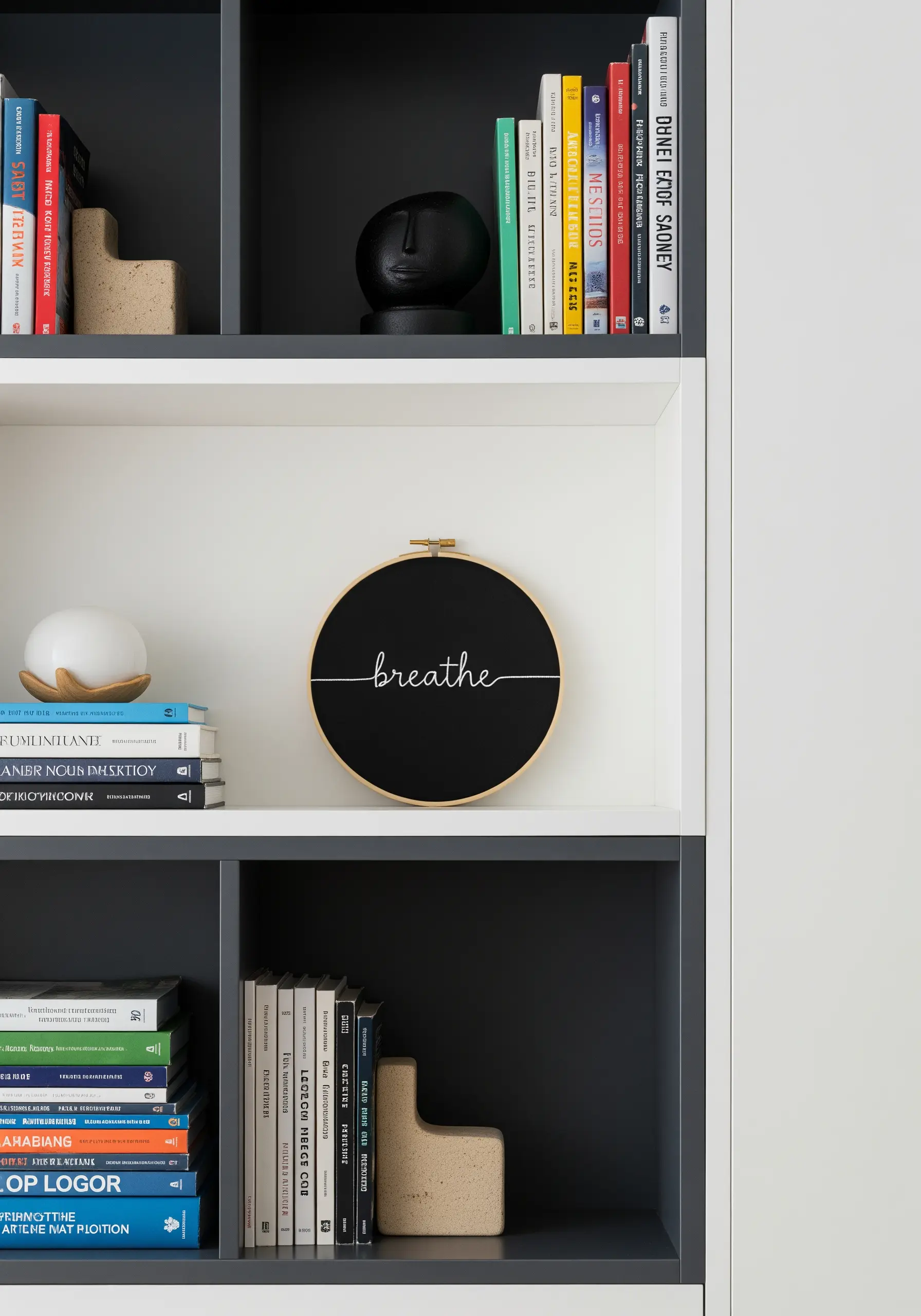 An embroidery hoop with the word 'breathe' stitched in white script on black fabric