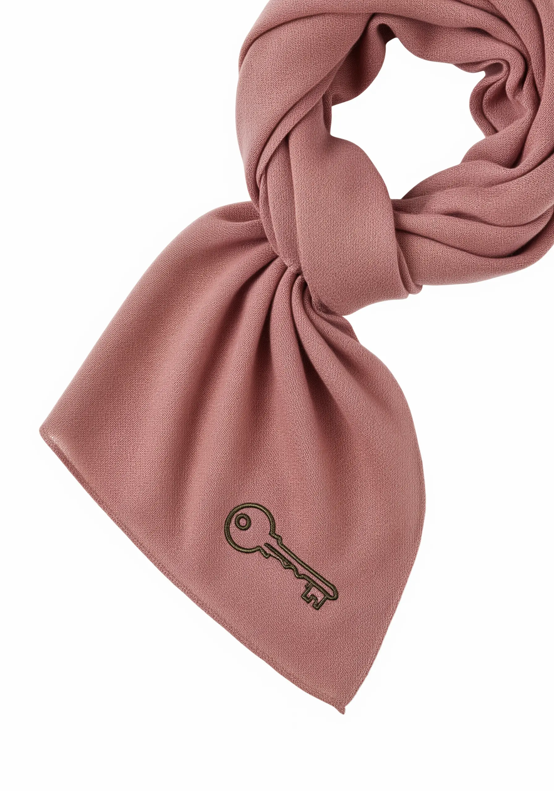 An intricate outline embroidery of a vintage key on a dusty rose scarf.