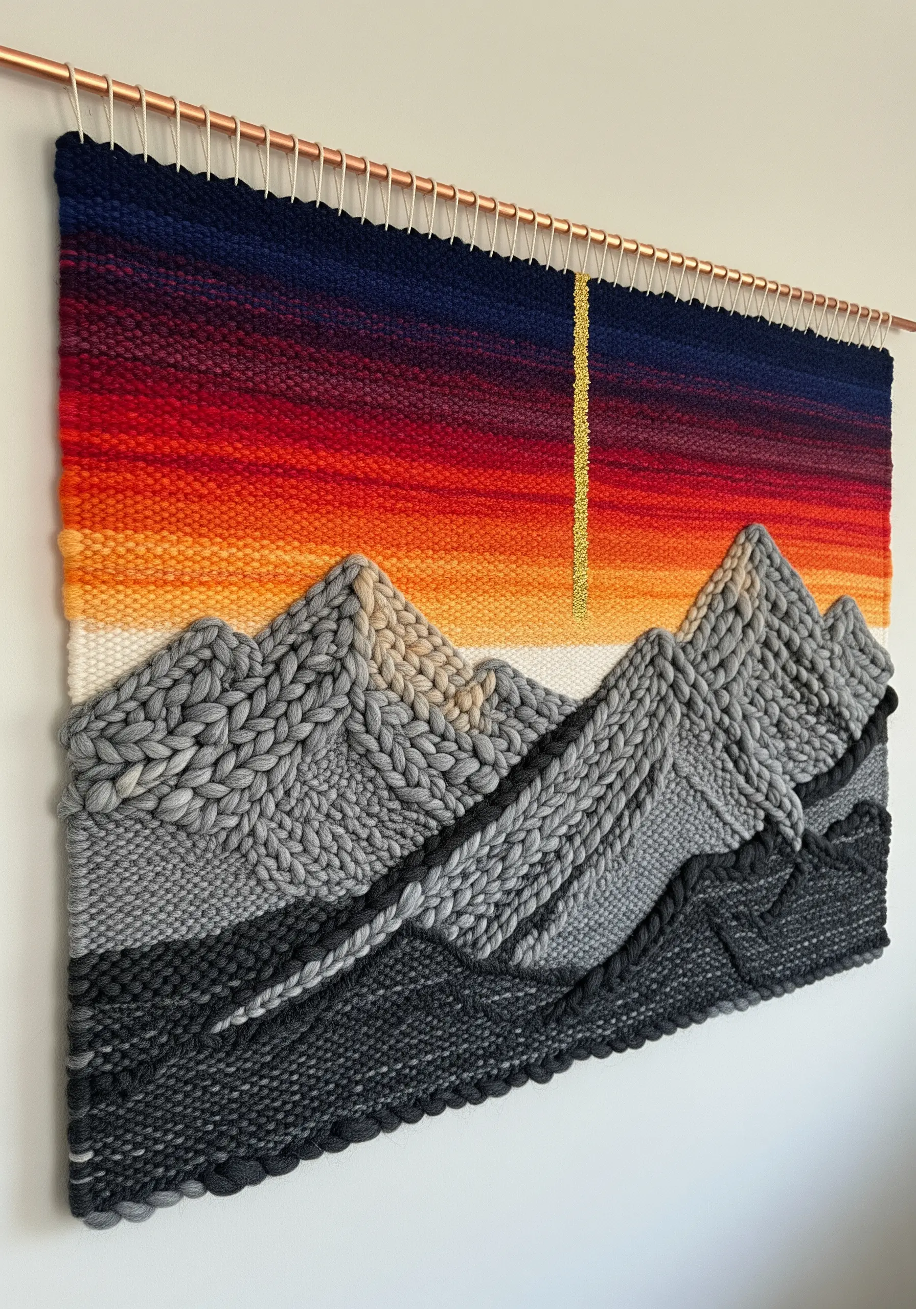 Woven wall hanging of a mountain range at sunset with textured, braided peaks.