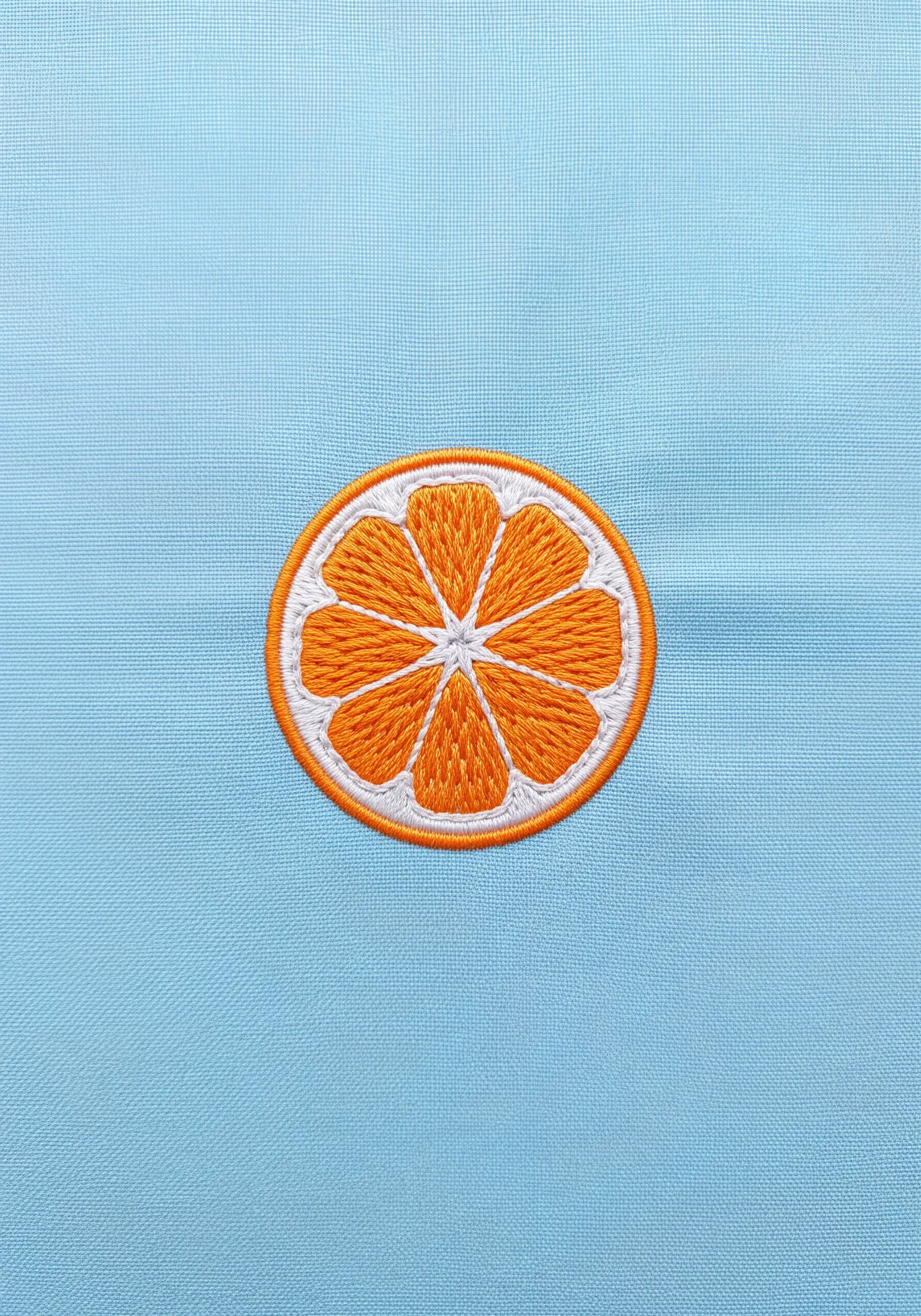 A vibrant embroidered patch of a round orange slice on a light blue background.