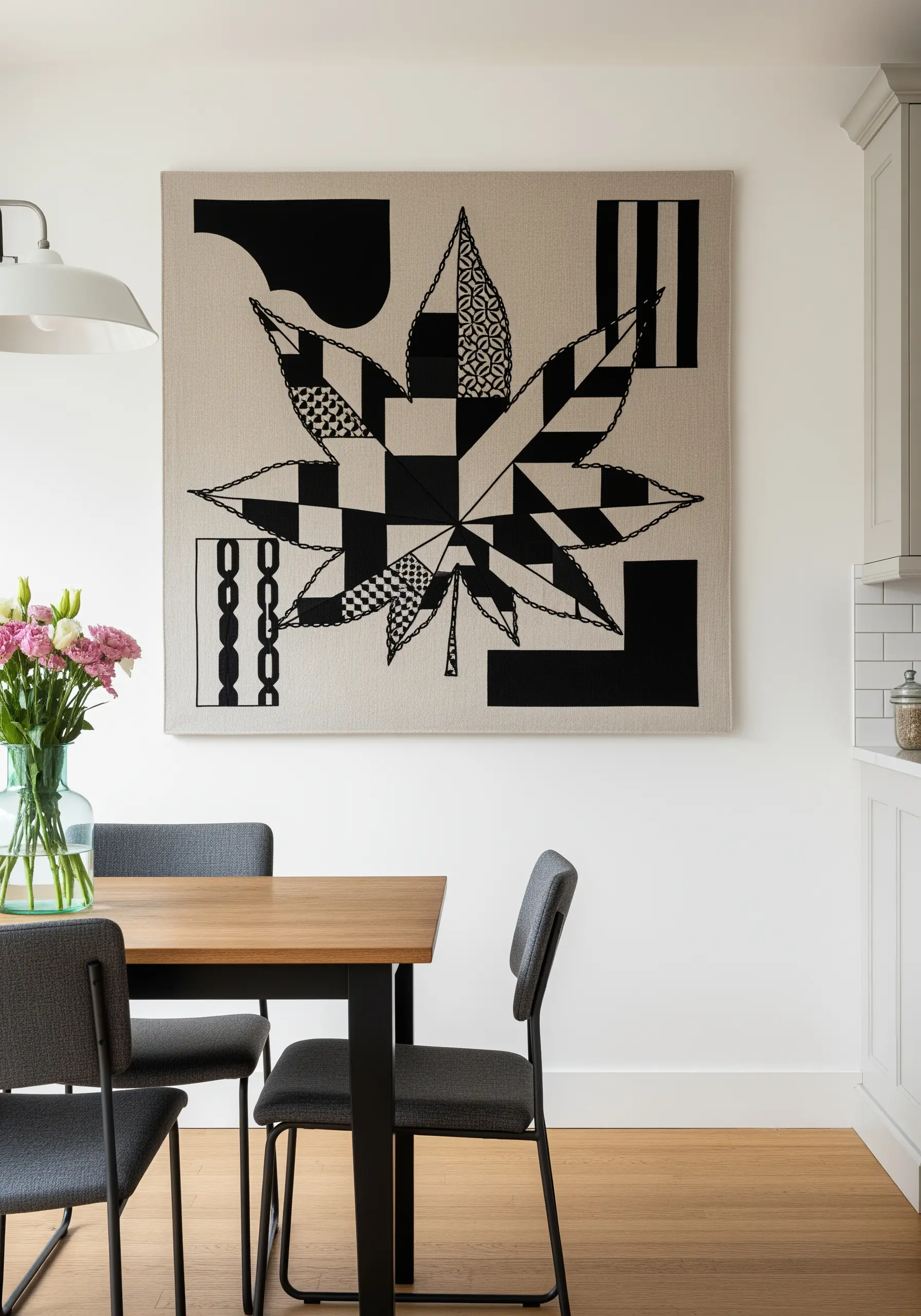 A large embroidered maple leaf filled with various black-and-white geometric patterns.