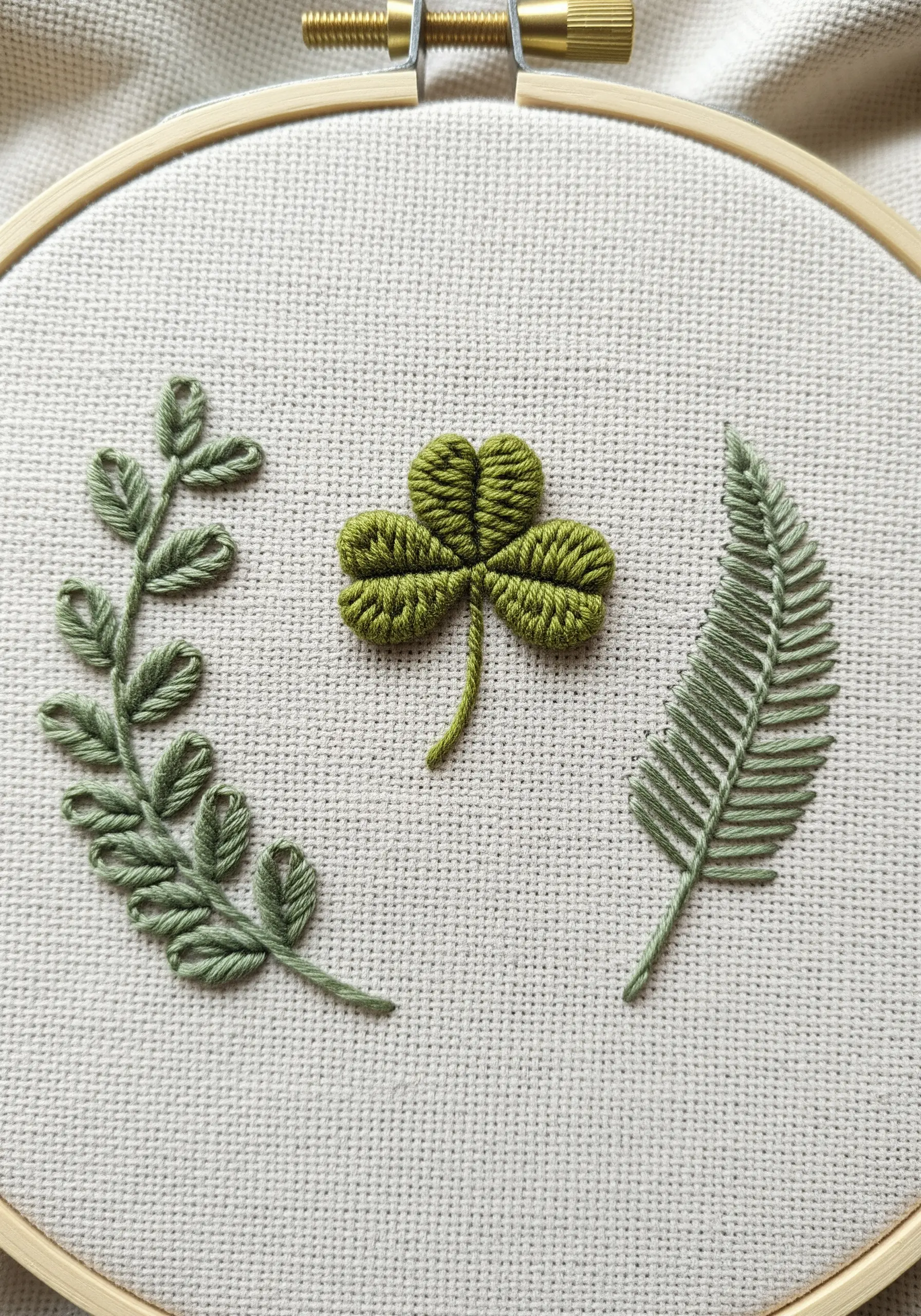A detailed sampler of leaf textures: satin stitch clover and fishbone stitch fern.