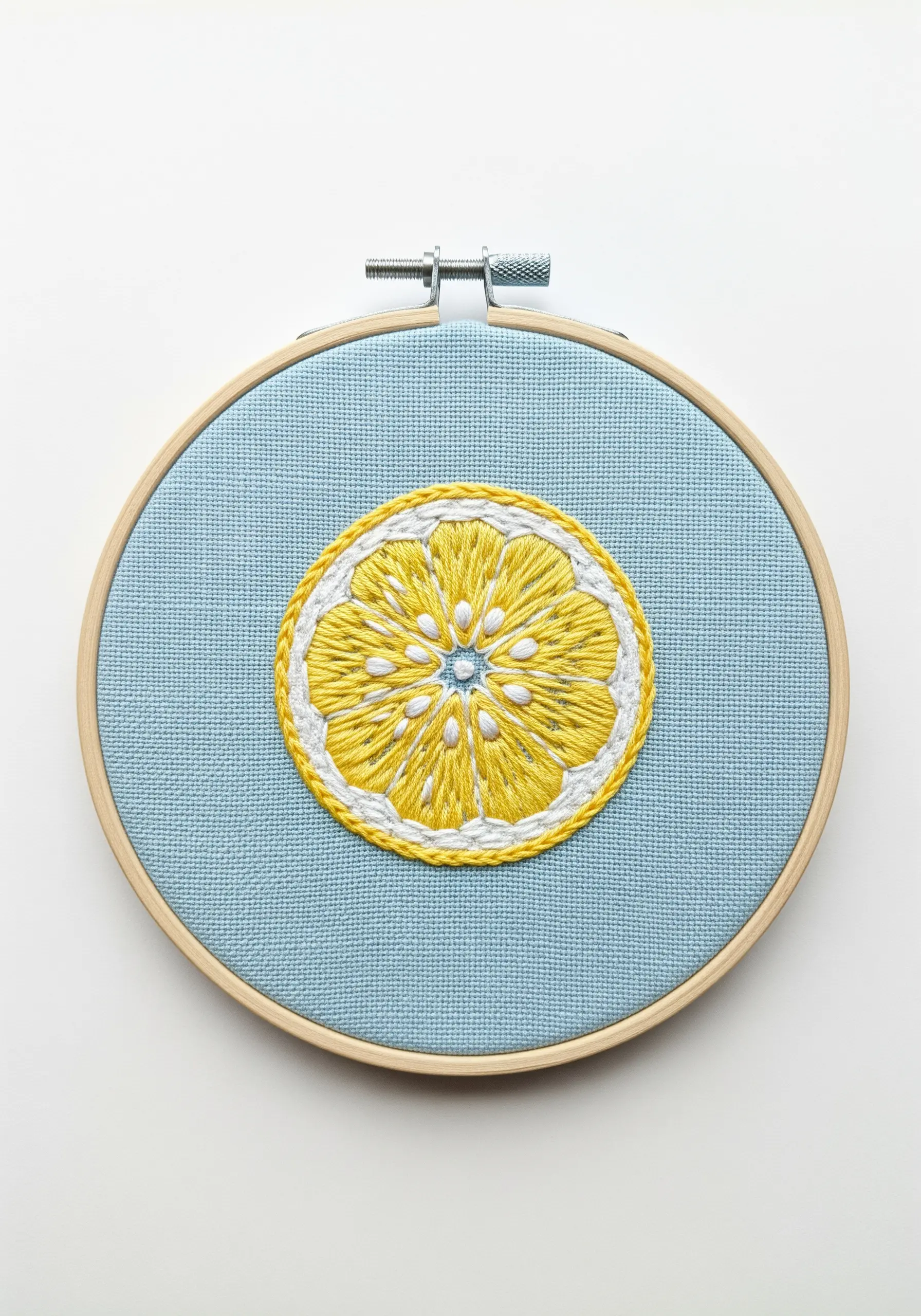 An embroidered lemon slice with yellow satin stitch segments and a white outline.