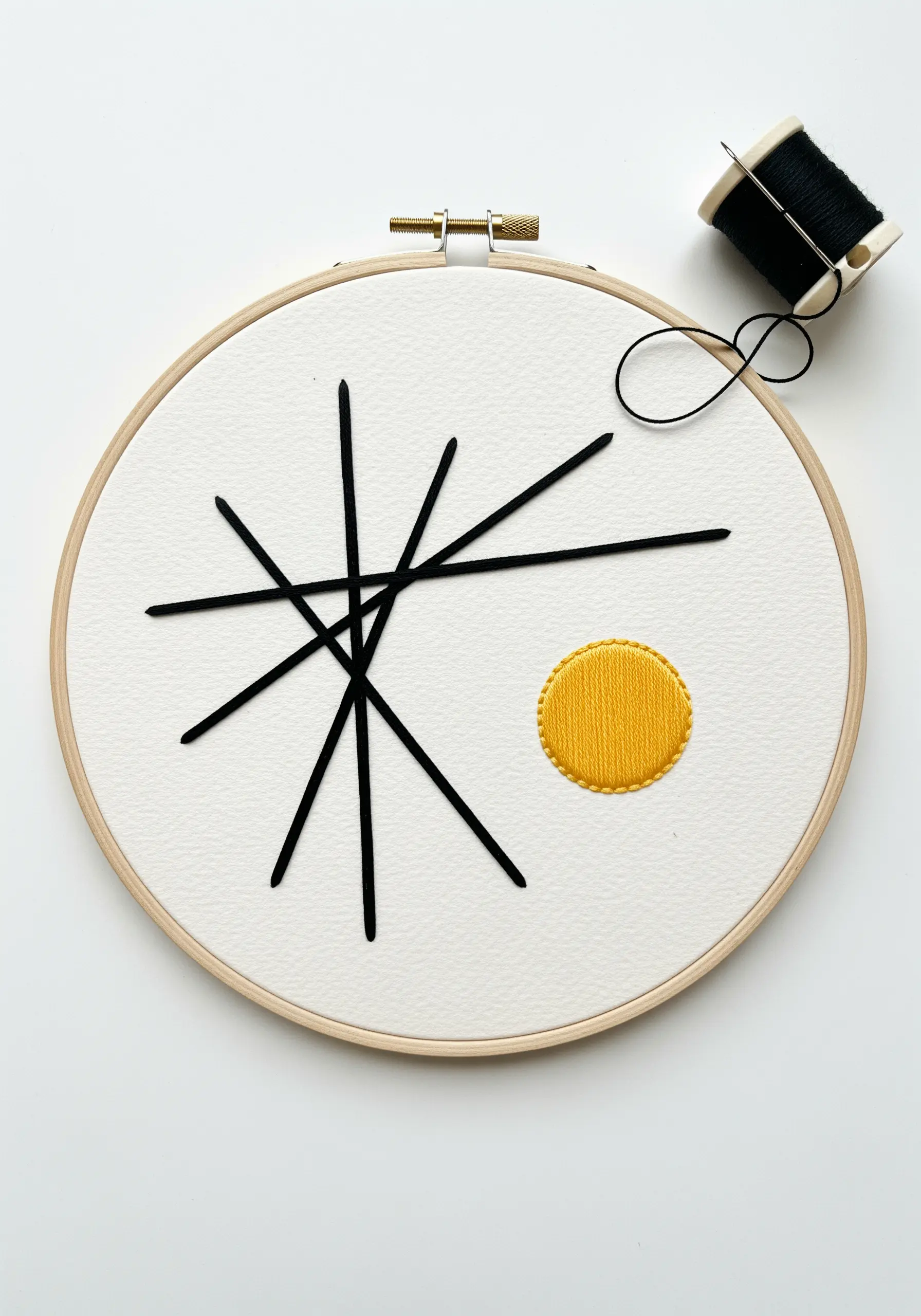 Abstract black line embroidery with a yellow satin-stitched circle on hooped paper.
