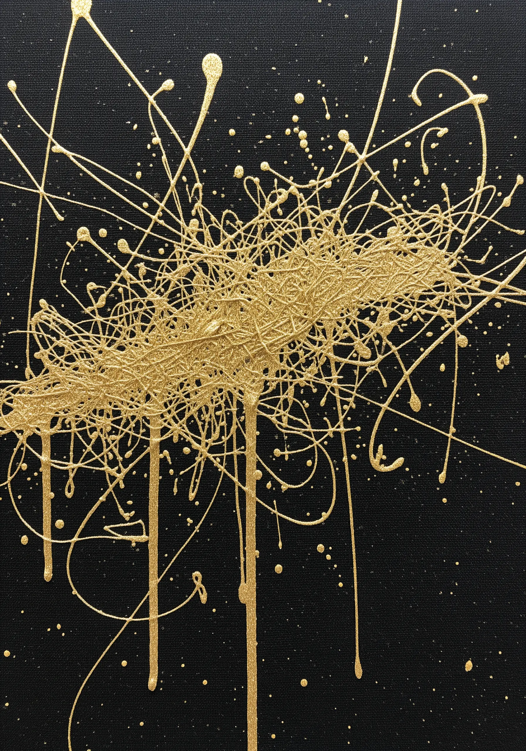 Gold thread arranged on a black canvas to look like dripping paint splatters.