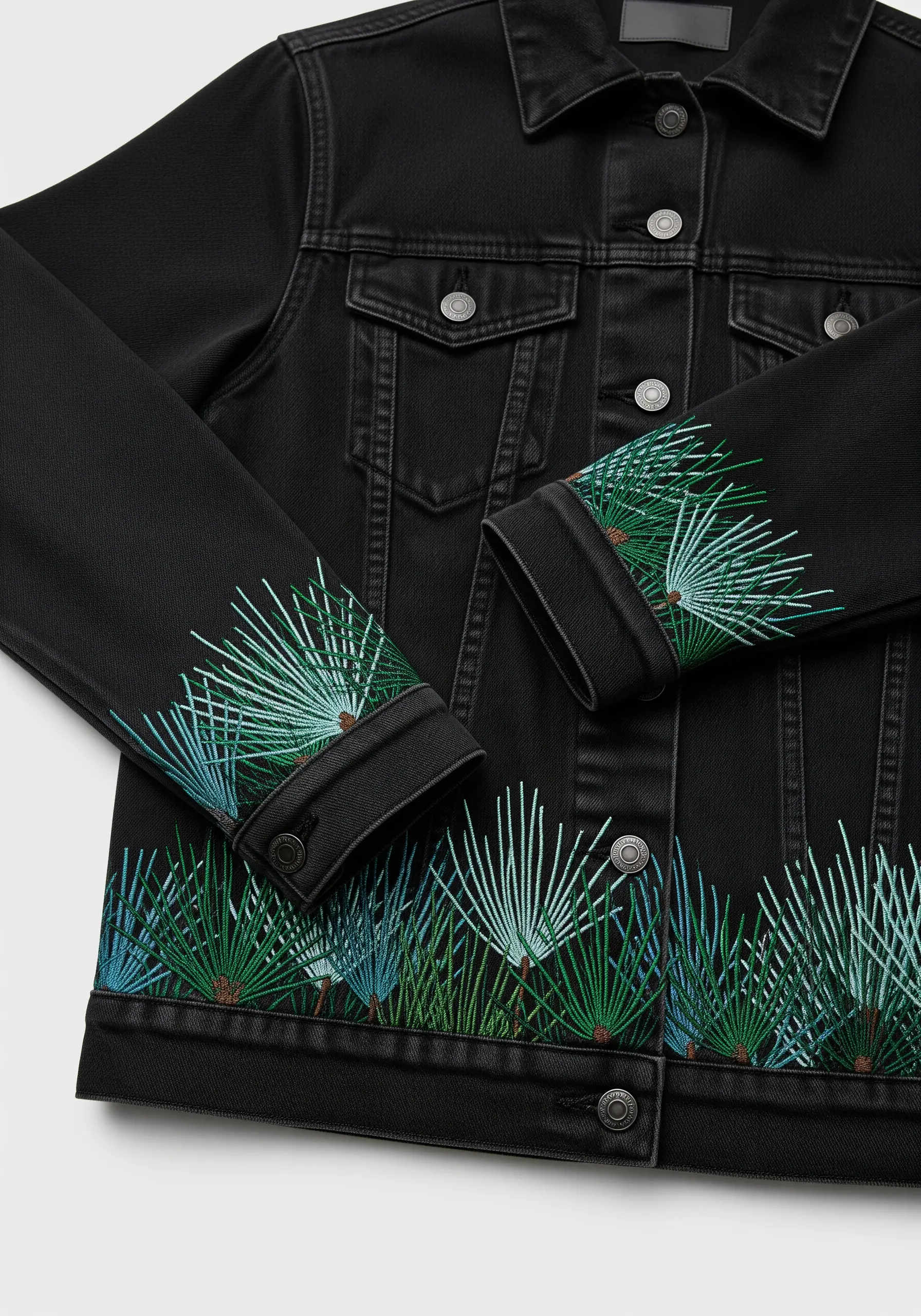 Abstract fan palm embroidery in blue and green gradients on jacket cuffs and hem.