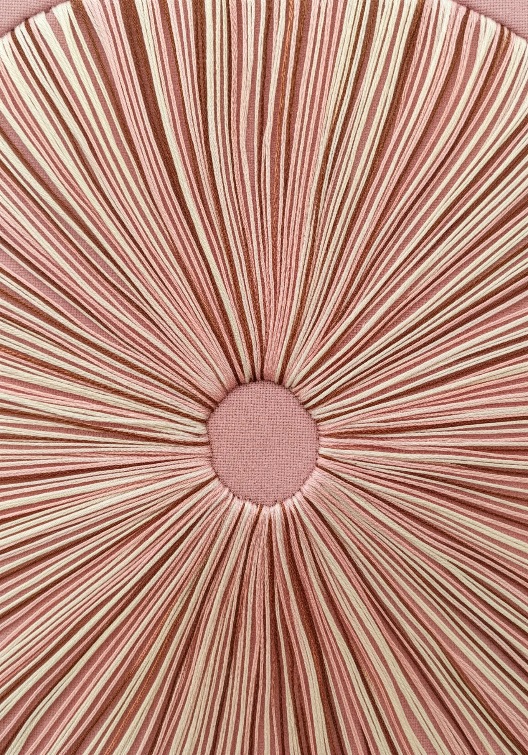 An abstract close-up of mushroom gills, created with radial stitches in pink and cream.