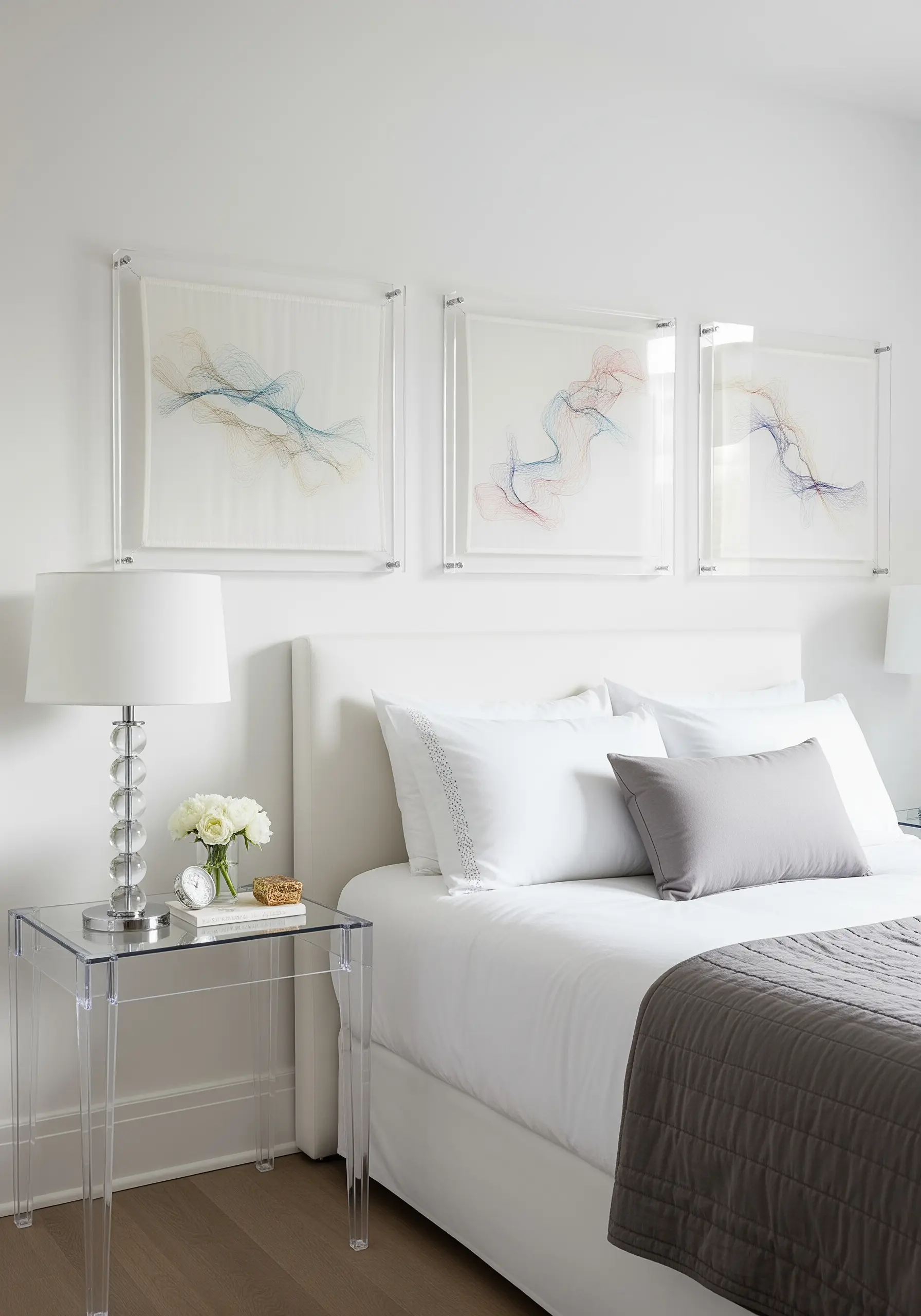 Abstract, flowing line embroidery in multiple colors on sheer fabric, mounted in clear acrylic frames.