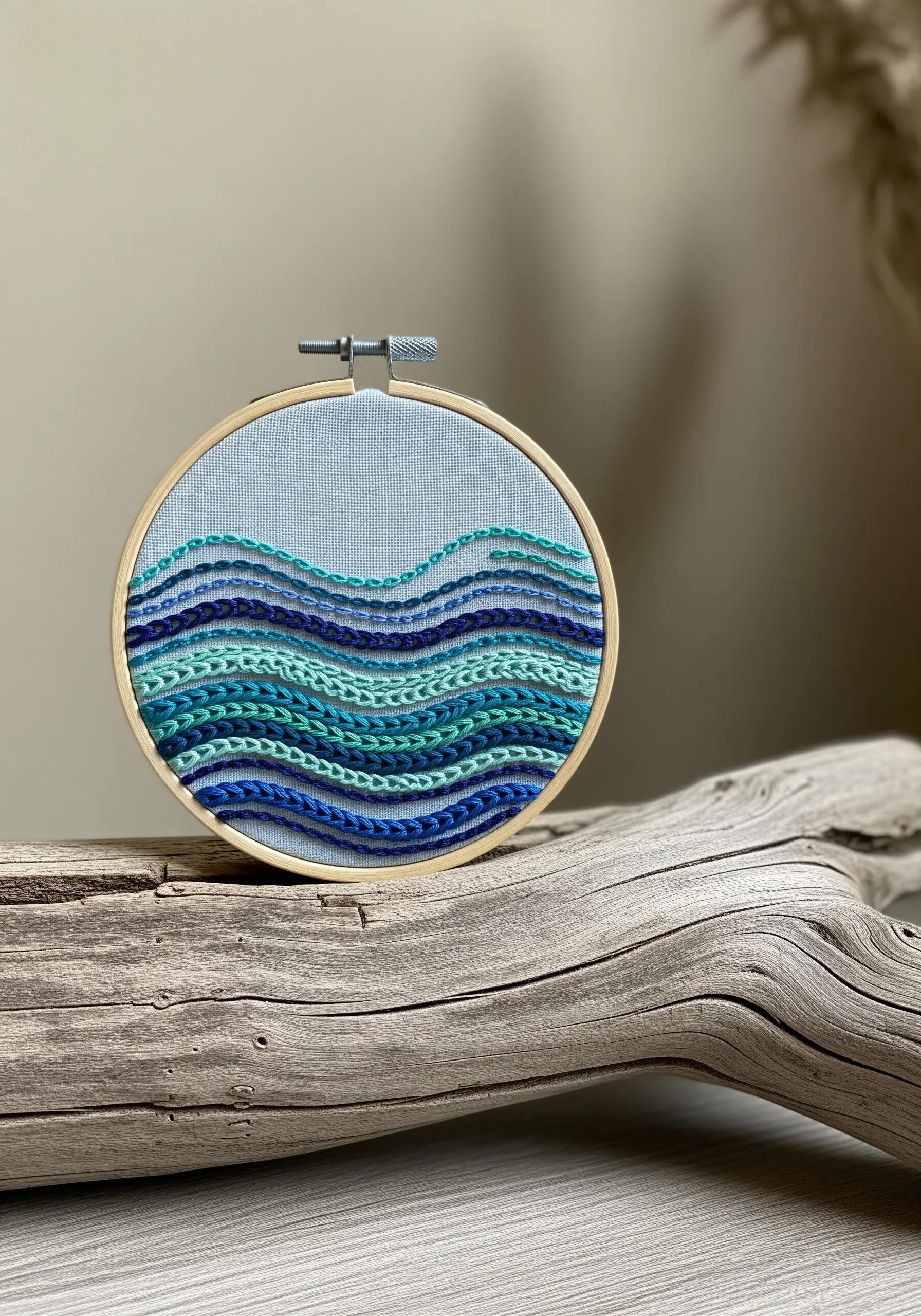 Abstract ocean waves created with layered rows of chain stitch in shades of blue.
