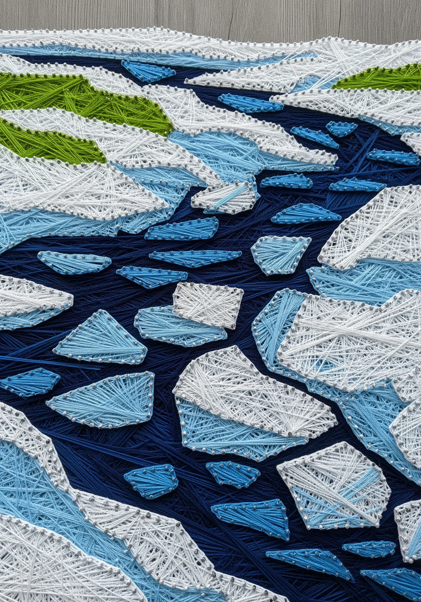 Abstract string art of white and blue ice floes on a dark blue background.