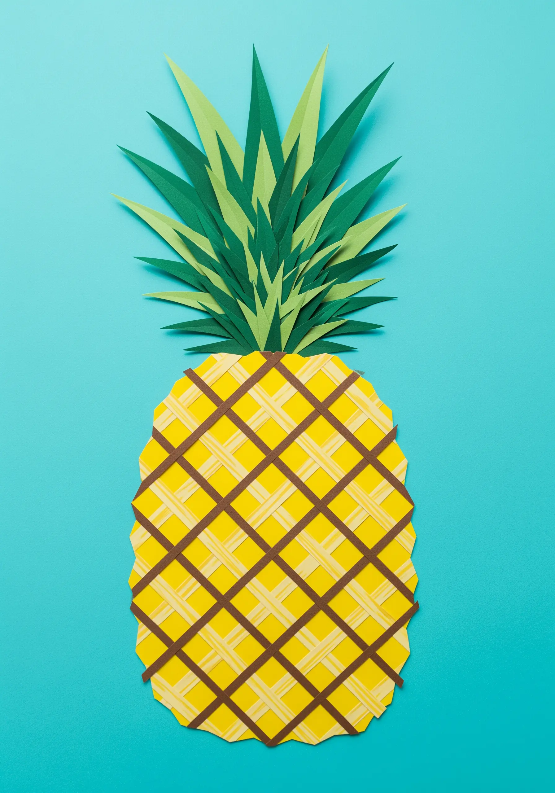 A paper pineapple with a woven, crosshatched body and spiky green leaves.