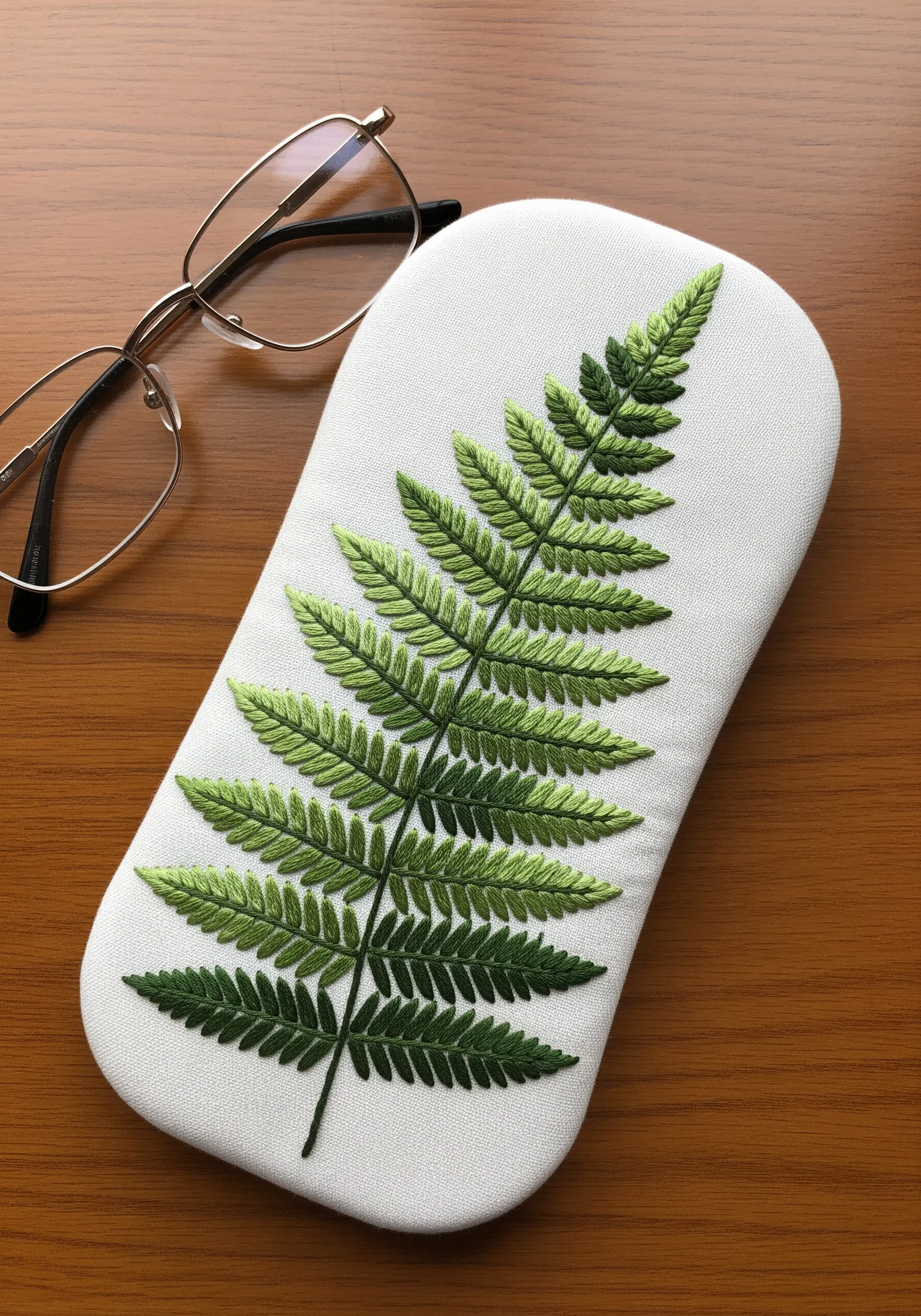 A large fern leaf with a perfect green color gradient on a white padded case.