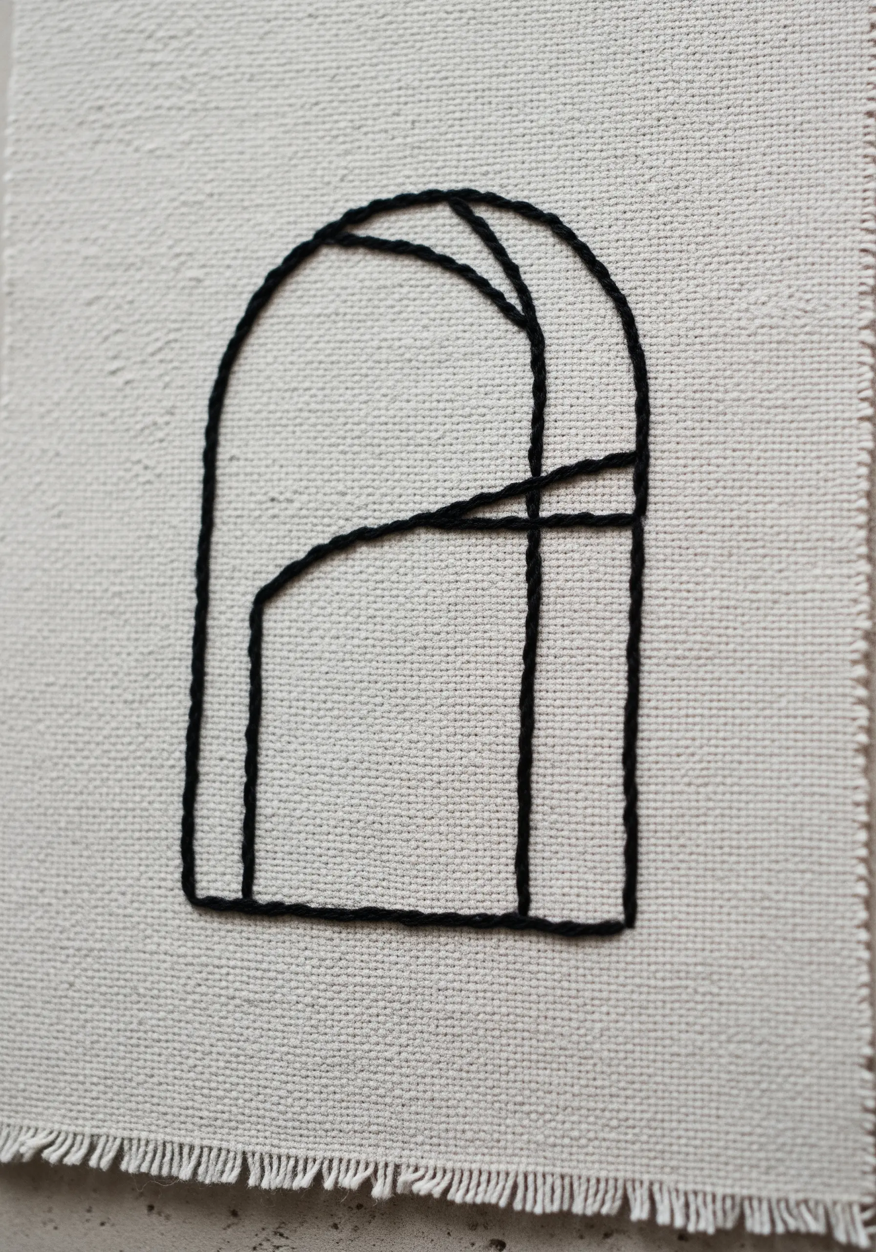 A minimal architectural arch design stitched in bold black whipped backstitch on canvas.