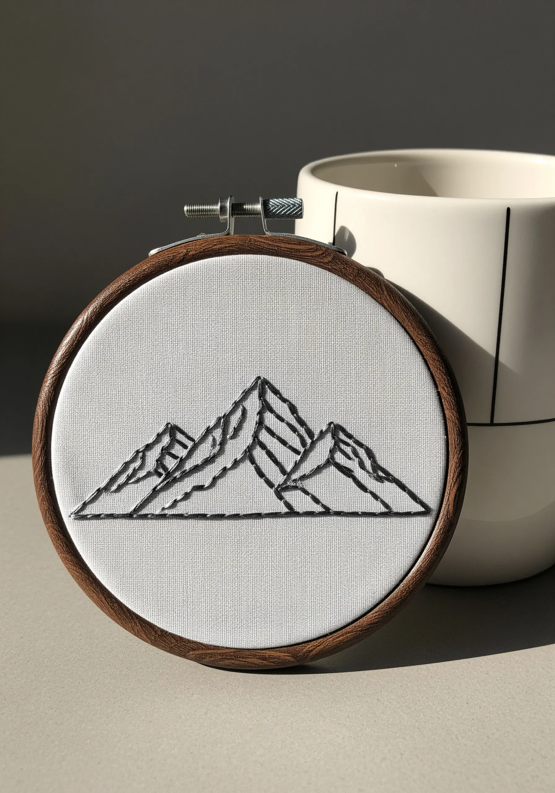 Minimalist mountain range outline embroidered in thick black thread.