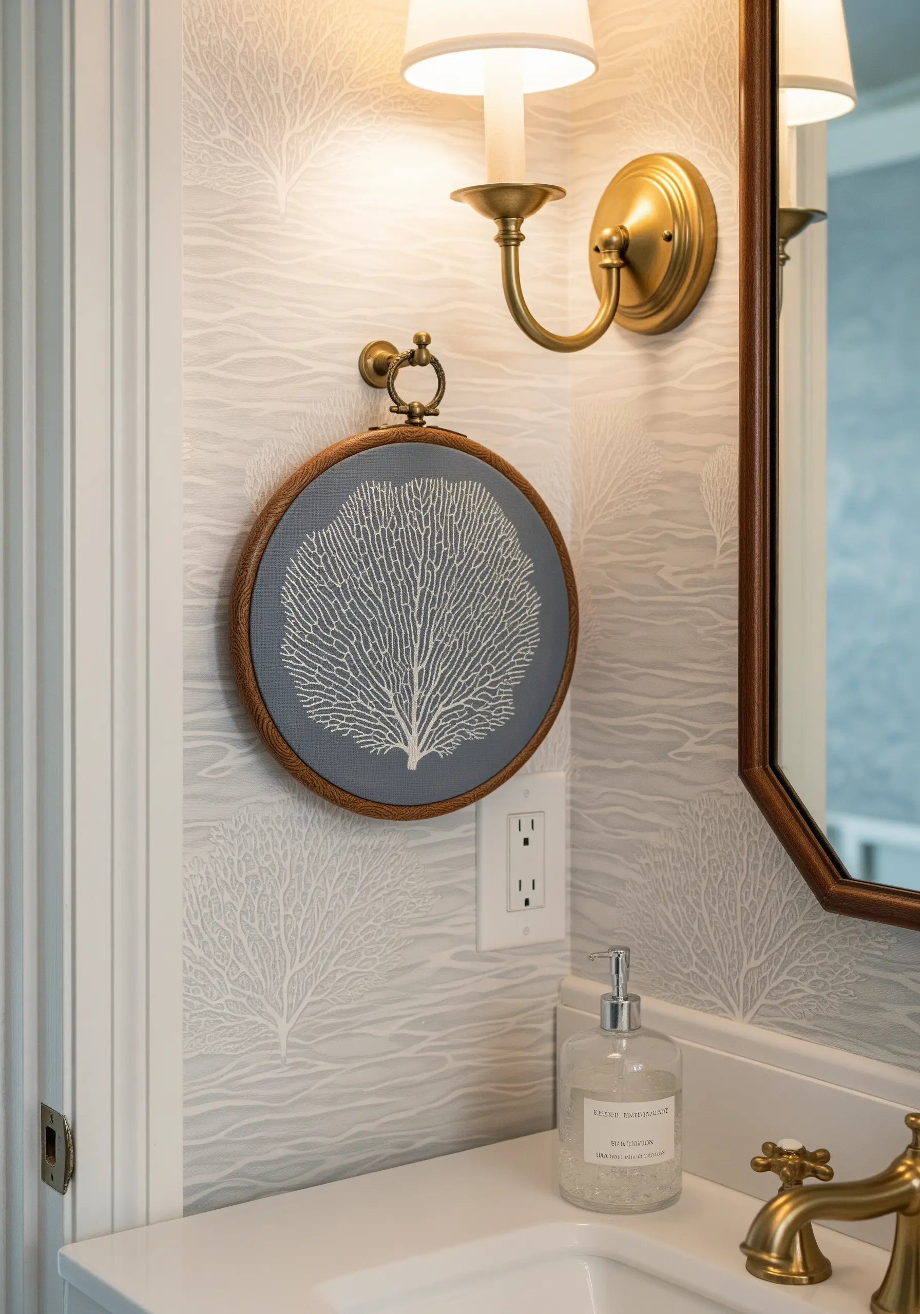 Detailed white embroidery of a sea fan coral on dark grey fabric in a stained wooden hoop.