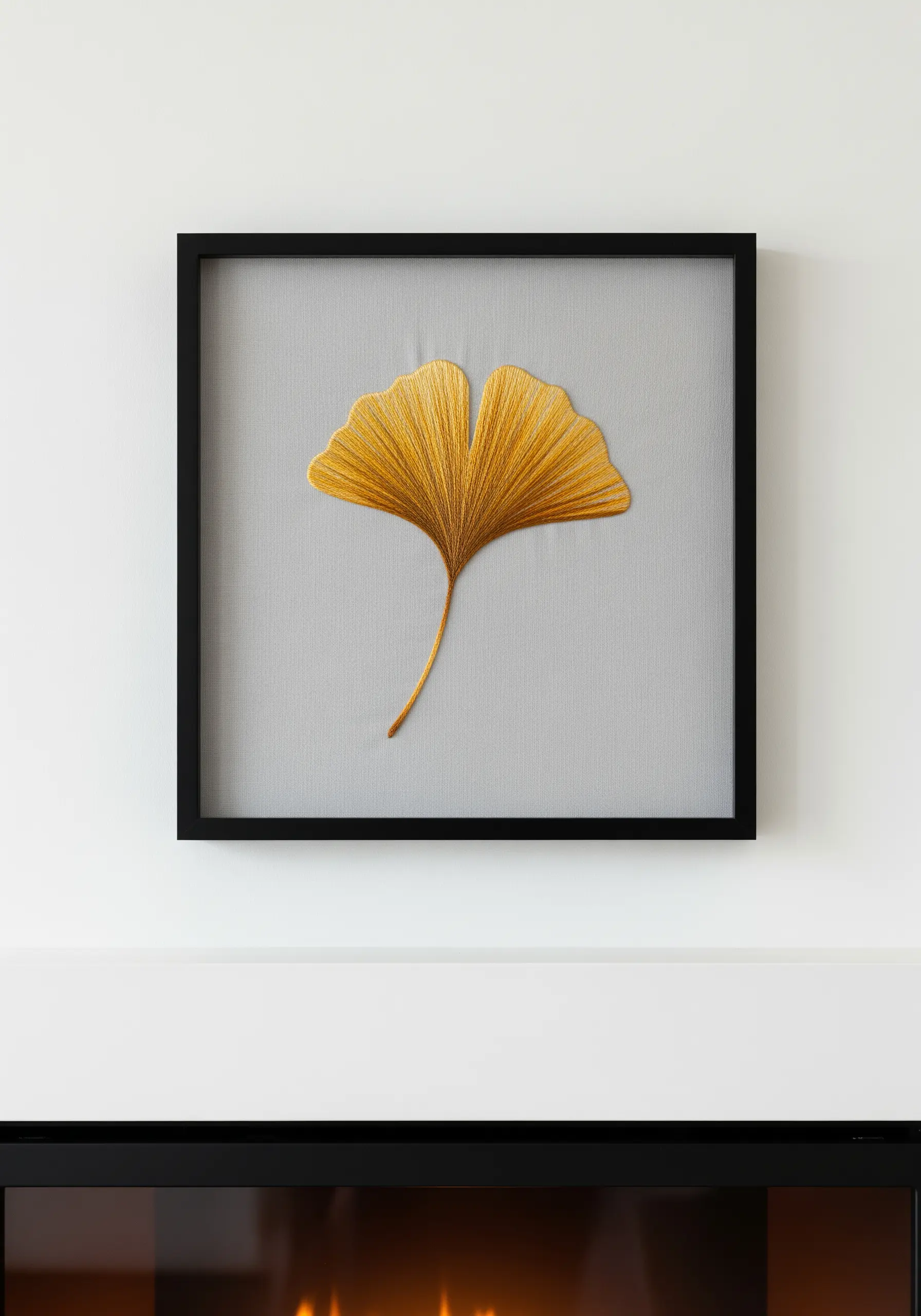 A framed ginkgo leaf embroidered with realistic thread painting in shades of gold and yellow.