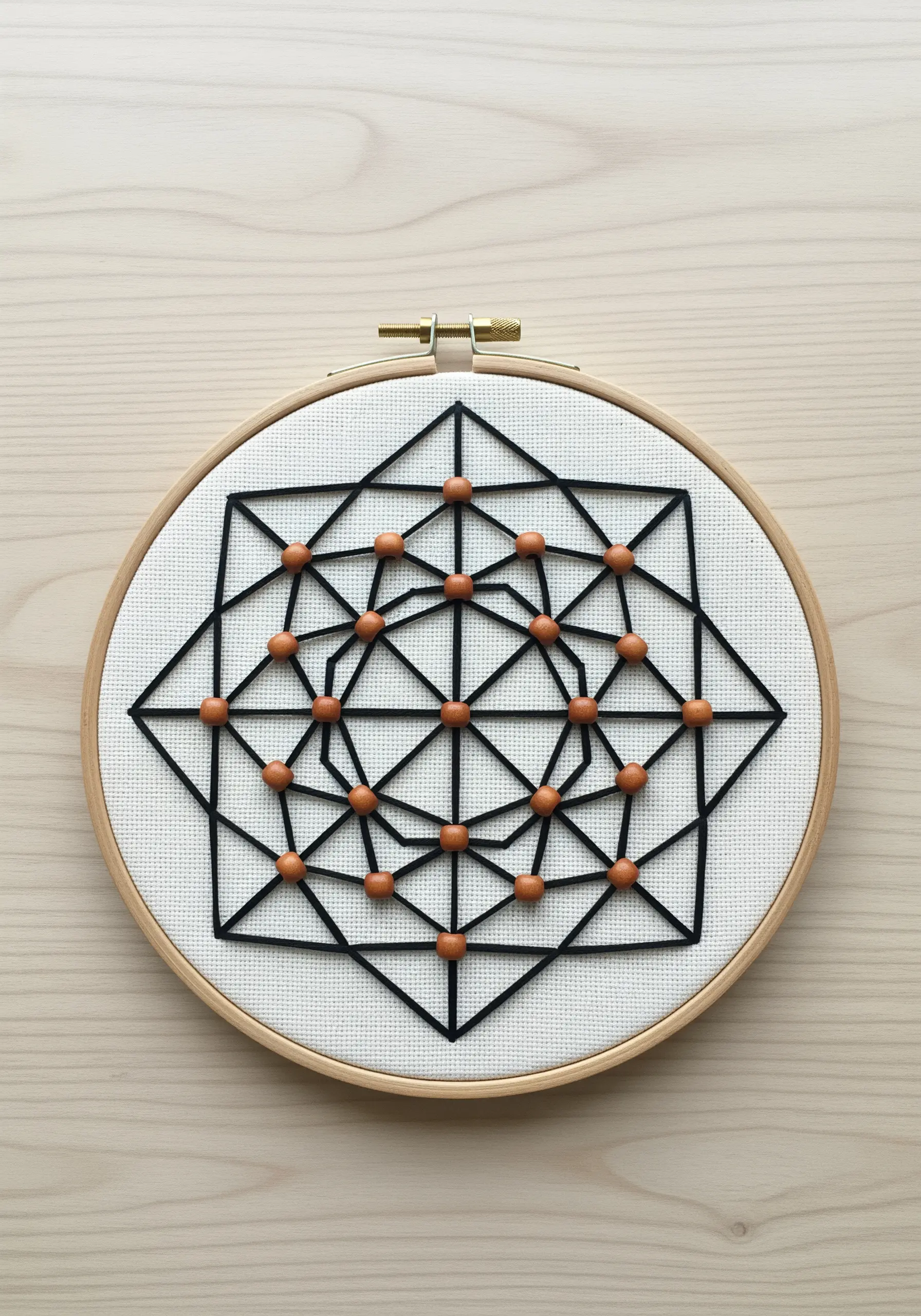 A black thread geometric mandala with wooden beads stitched at the intersections.