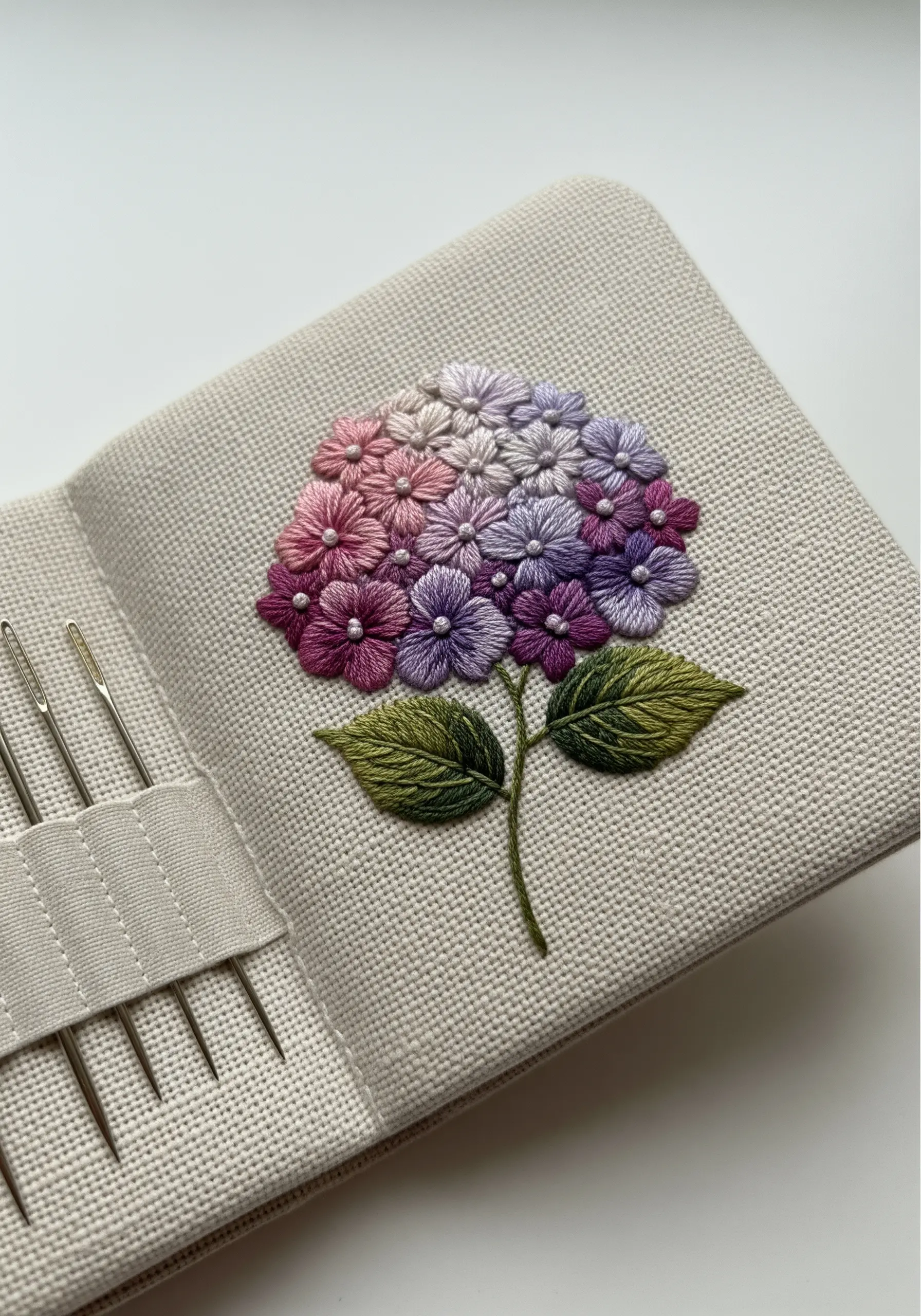 Embroidered needle book with dimensional pink and purple hydrangeas and beaded centers.