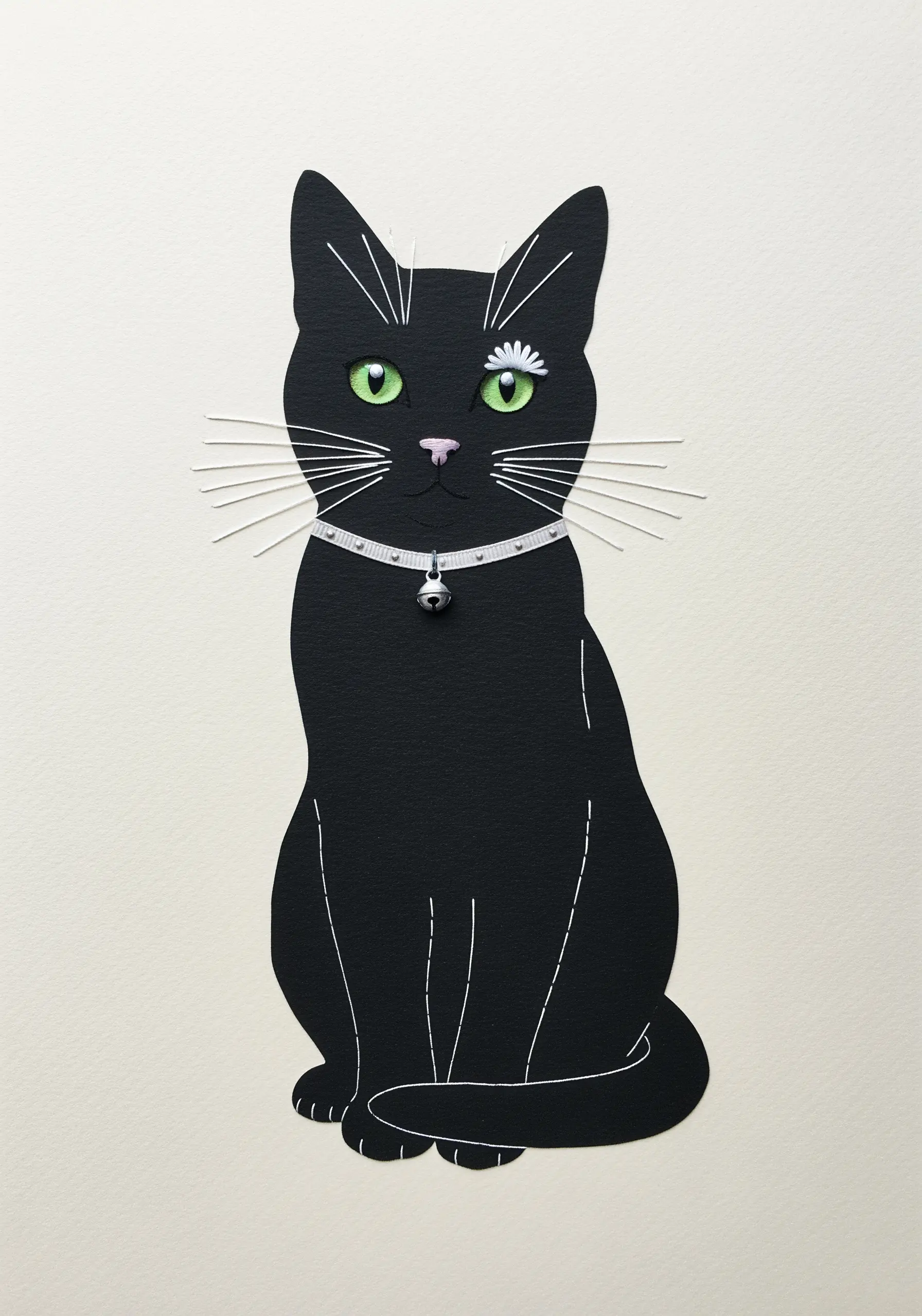 A black paper cat silhouette embellished with white thread whiskers and a tiny embroidered daisy.