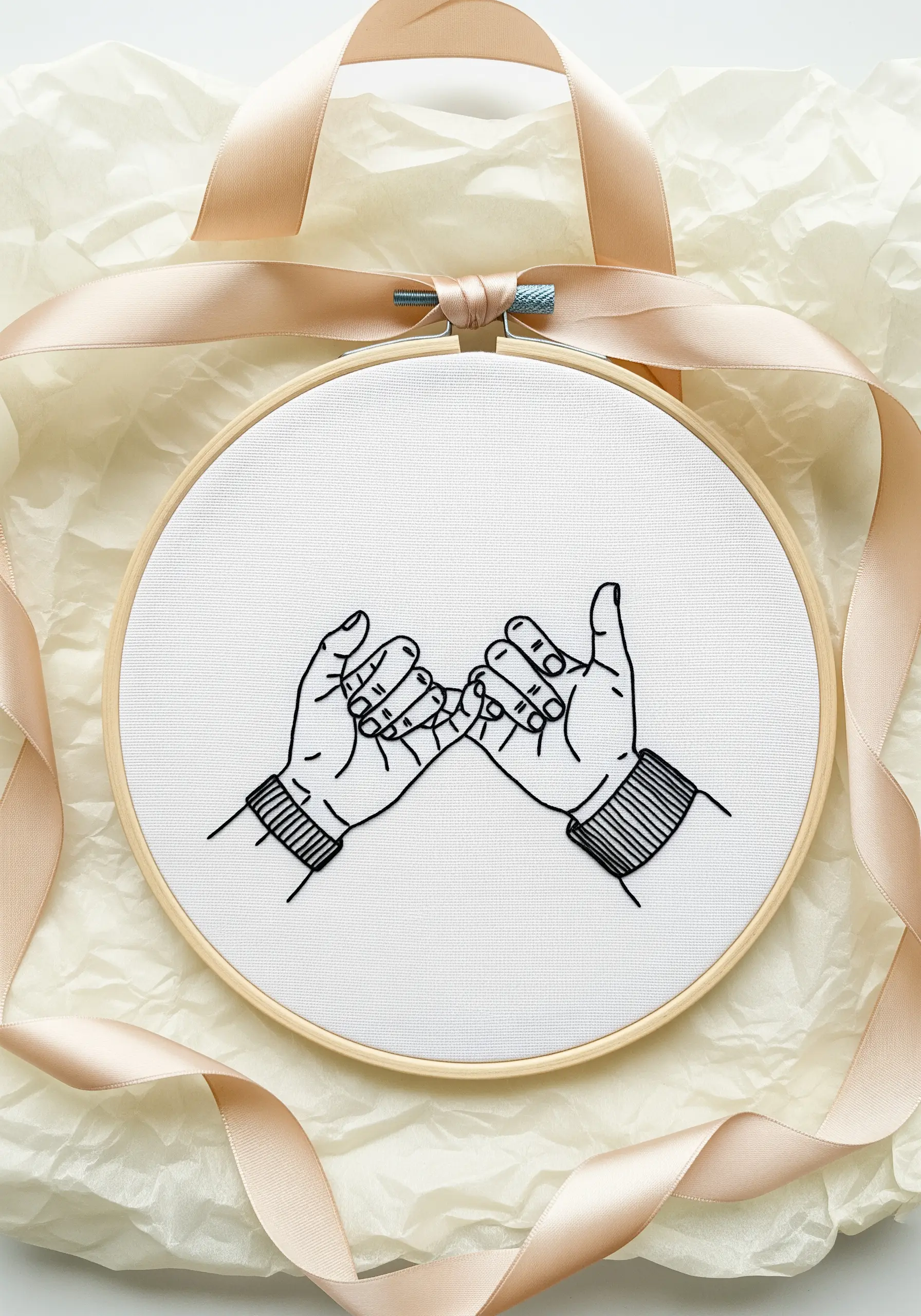 Line art embroidery of a pinky promise, with black satin stitch filling the sweater cuffs.
