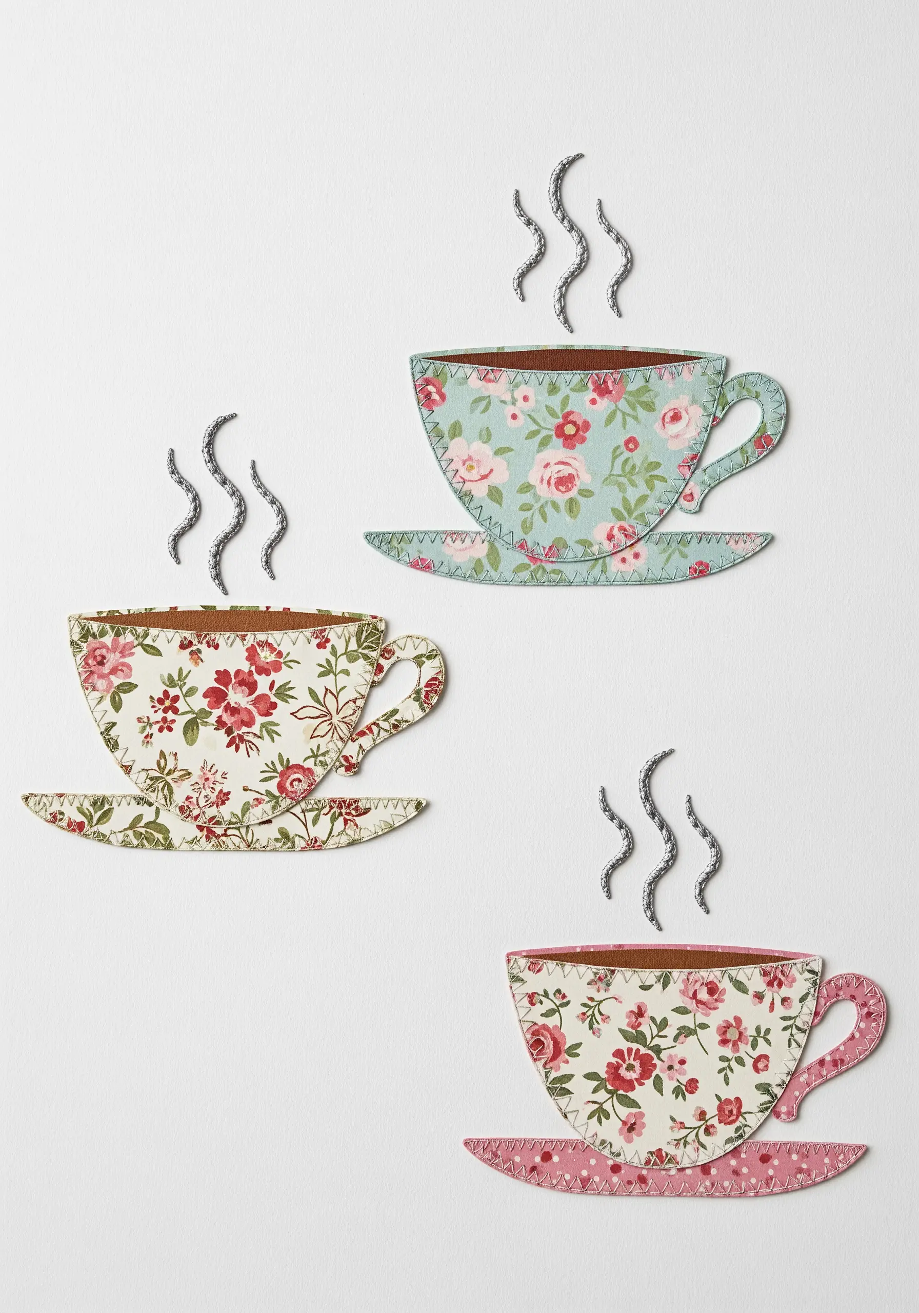 Teacups made from floral paper cutouts with stitched edges and metallic thread steam.