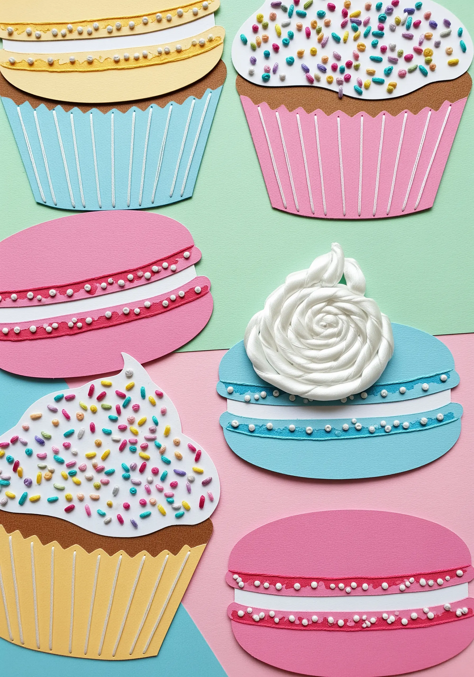 Paper collage cupcakes and macarons decorated with tiny embroidered stitches as sprinkles and filling.