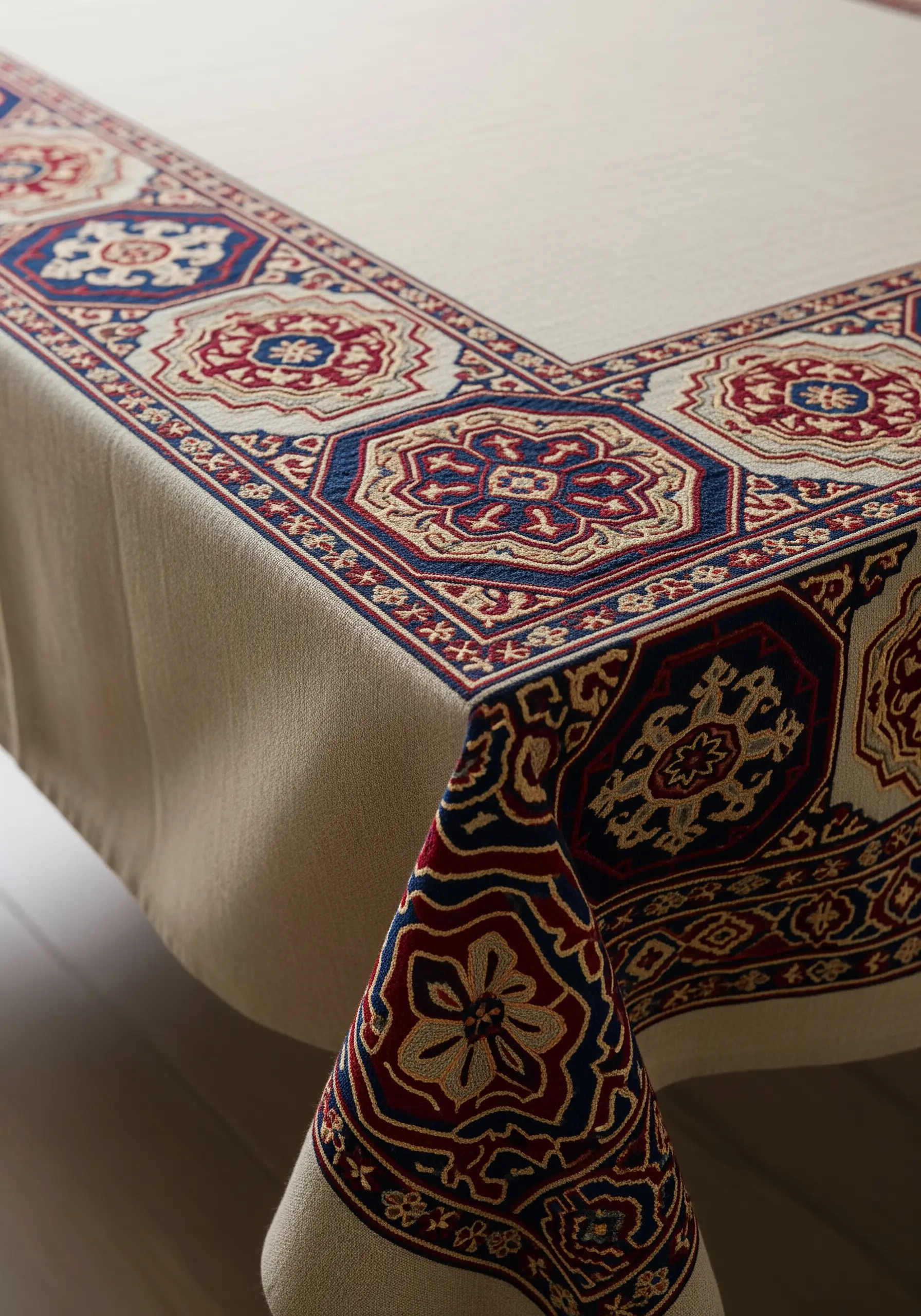 A tablecloth corner with an embroidered border inspired by Turkish Kilim rug patterns.